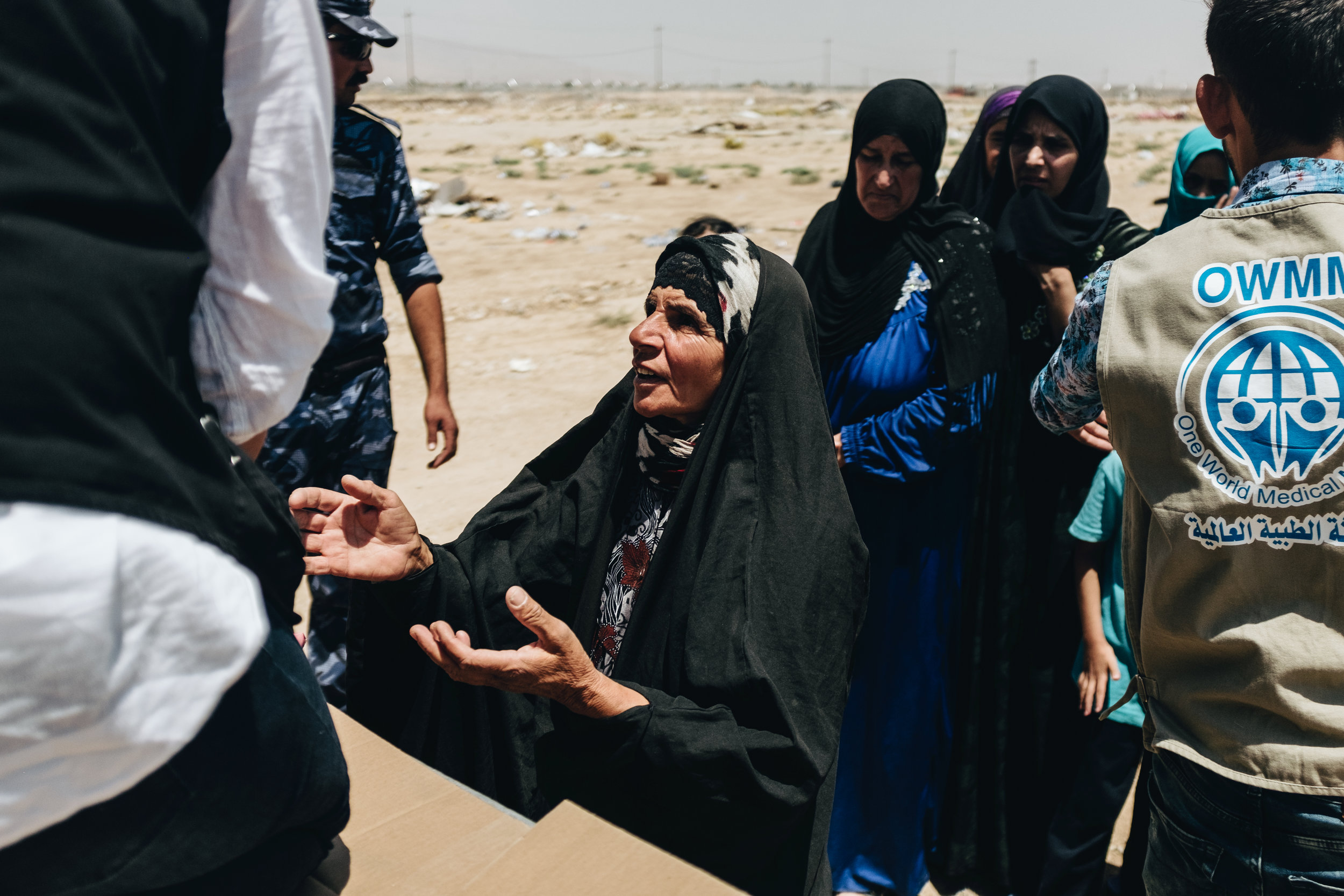 An elderly woman stand at the back of the aid distribution truck in the Bartalla IDP camp waiting to recieve essential supplies such as nappies, baby formula, tooth brushes and other essential supplies. Because of the families suspected links to fighters, many NGOs are reluctant to provide any assistance to the camp for fear of being seen to be sympathetic to ISIS.
