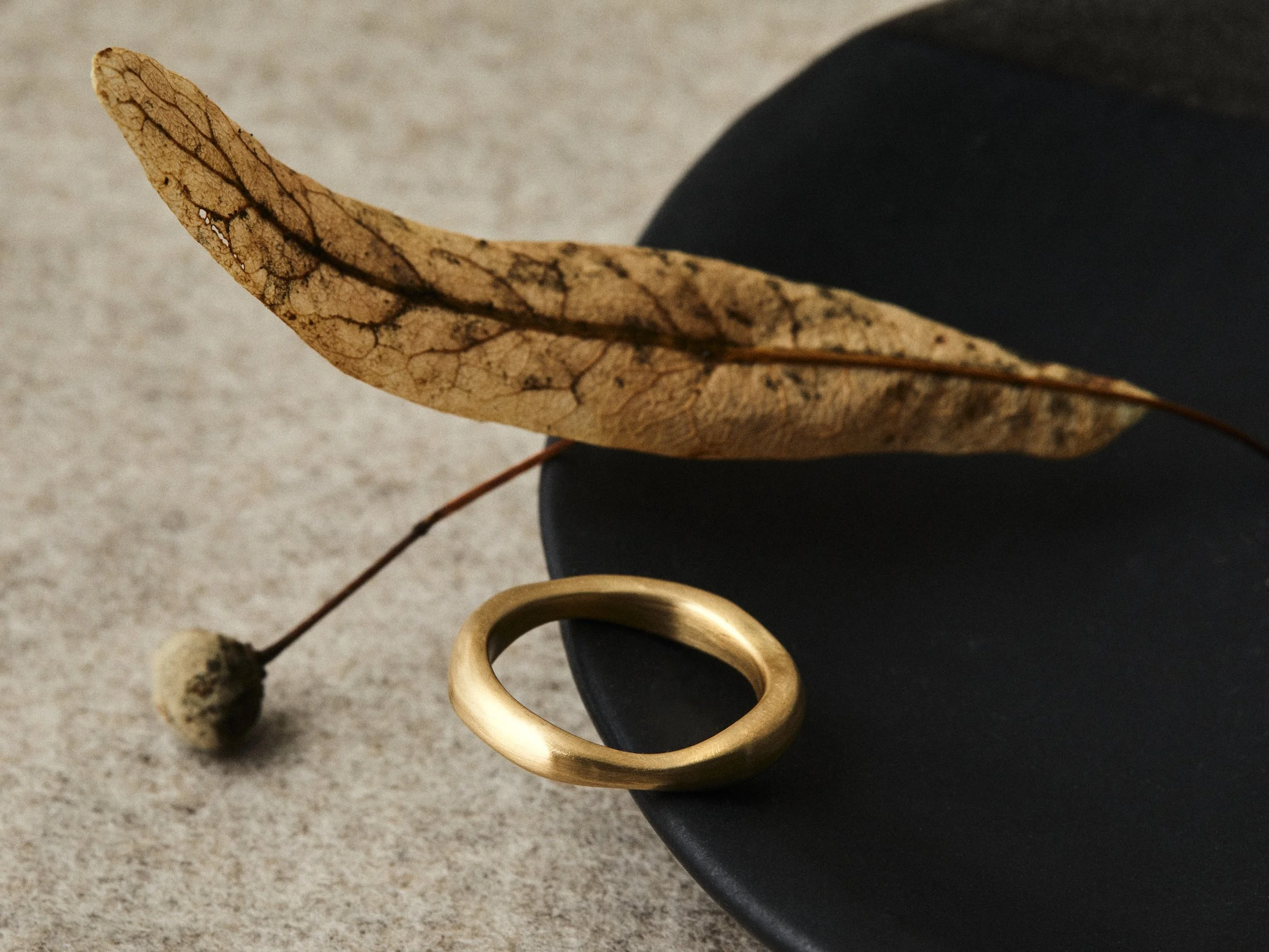 18ct+Yellow+Gold+Ring+still+life+with+black+ceramic+dish+and+leaf.jpg
