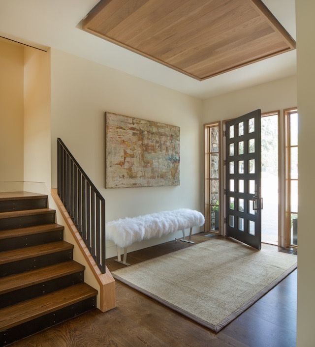 This entry makes a statement with a custom made shearling bench . You can find similar sheepskin at Celtic & Co . It sets a modern tone in this mountain retreat. 