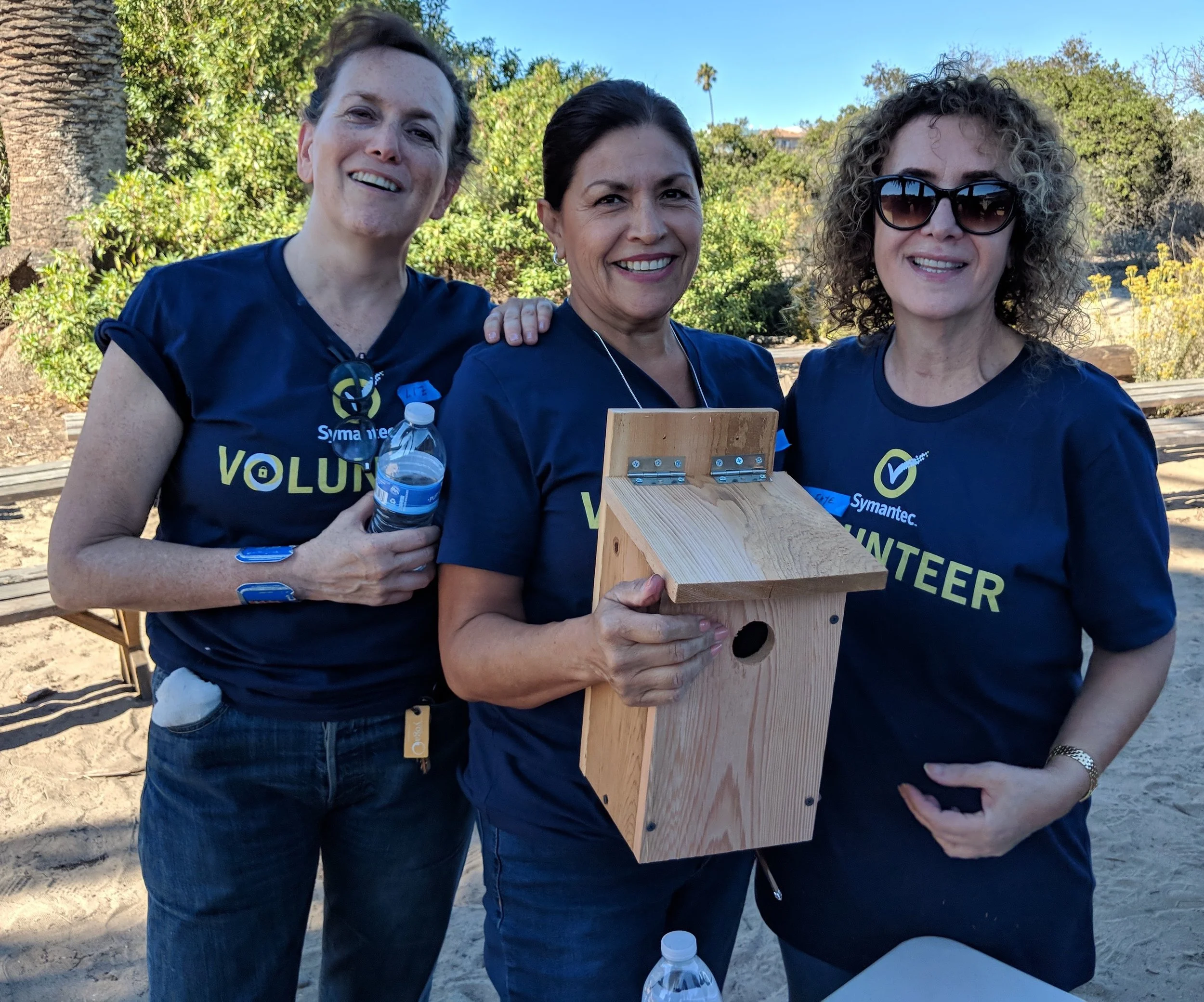 Symantec employees hold nesting boxes they created as part of a creek cleanup they participated in near Los Angeles in 2018.