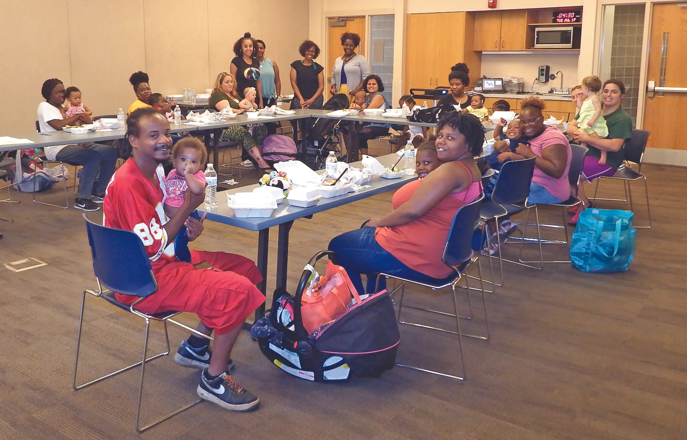From left: PAT Parent-Educator Tara Ervin, Donna Givens, manager of community partnerships and groups; Aminah Williams, parent educator, and Chiffontae Ross, model implementation specialist, look on as Terrence Trice holds his six-month-old daughter, Tayaina, as wife, Shaela, attends to Shaina, 6, during the Show Me Strong Families Goal$ and Assets: Family Conversations about Money financial literacy program. The class consisted of 13 families who gathered at a group connection for learning about managing money.