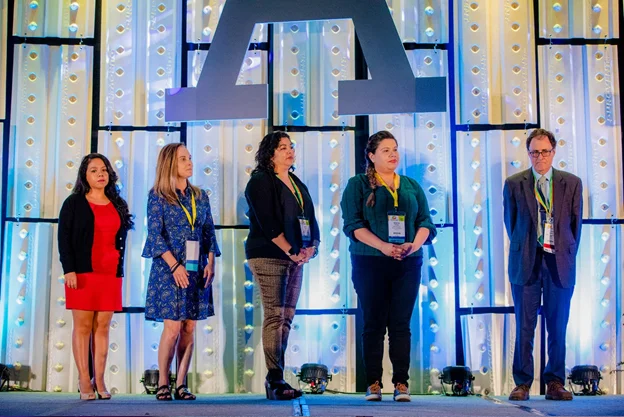 Representatives from the Arizona-based The Child and Family Resources, Building Bright Futures PAT Home Visitation Programs gather on stage to receive the Losos Award for Excellence. At right is PAT Board Director Francis Rushton.