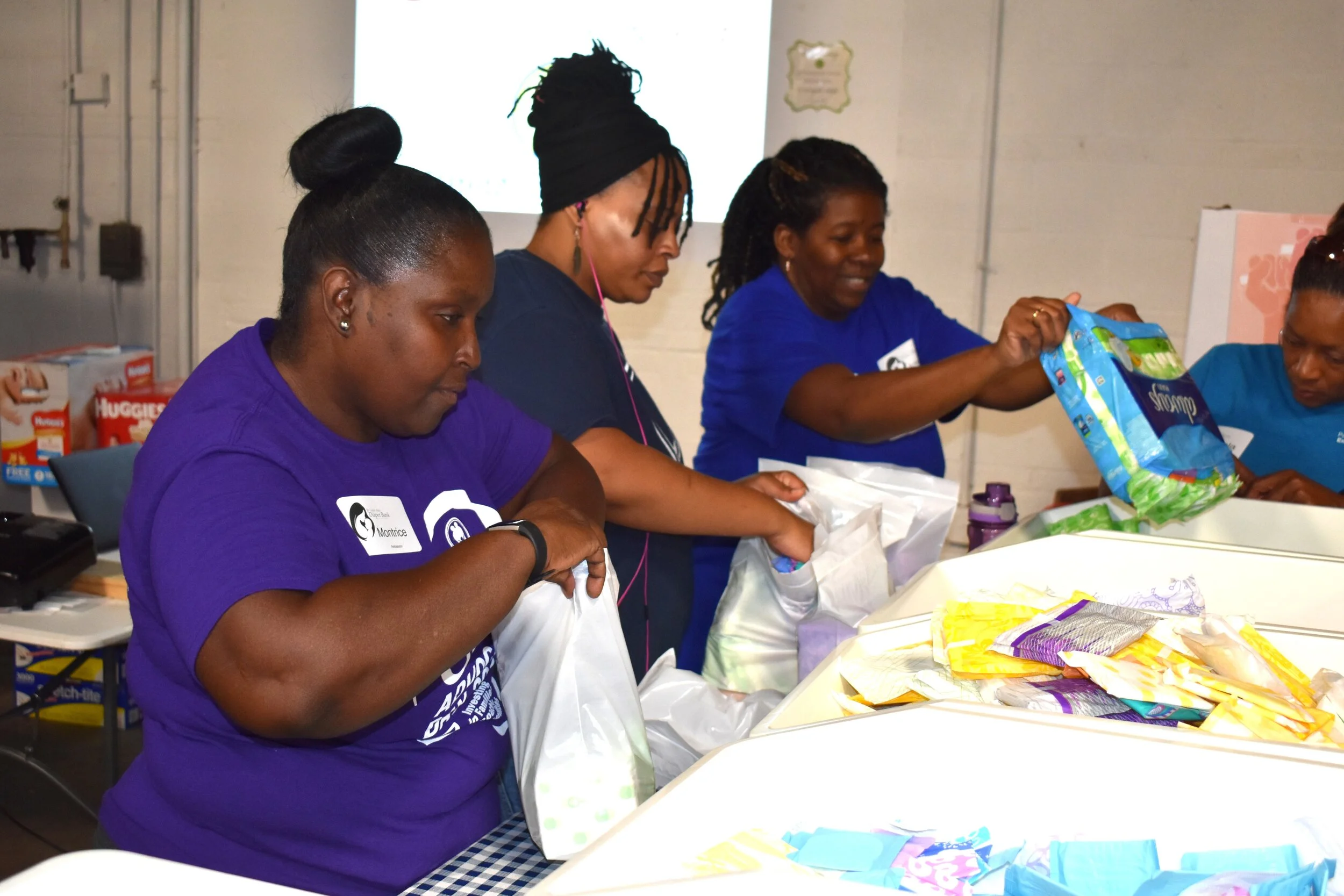 From left: Parents as Teacher staffers Montrice Humphrey, Carmen Qualls, Antionette Becerra, and Angela Gardner prepare feminine hygiene product kits for distribution to area low-income women at the St. Louis Diaper Bank as part of PAT’s giving back to the community initiative on the National Day of Service.