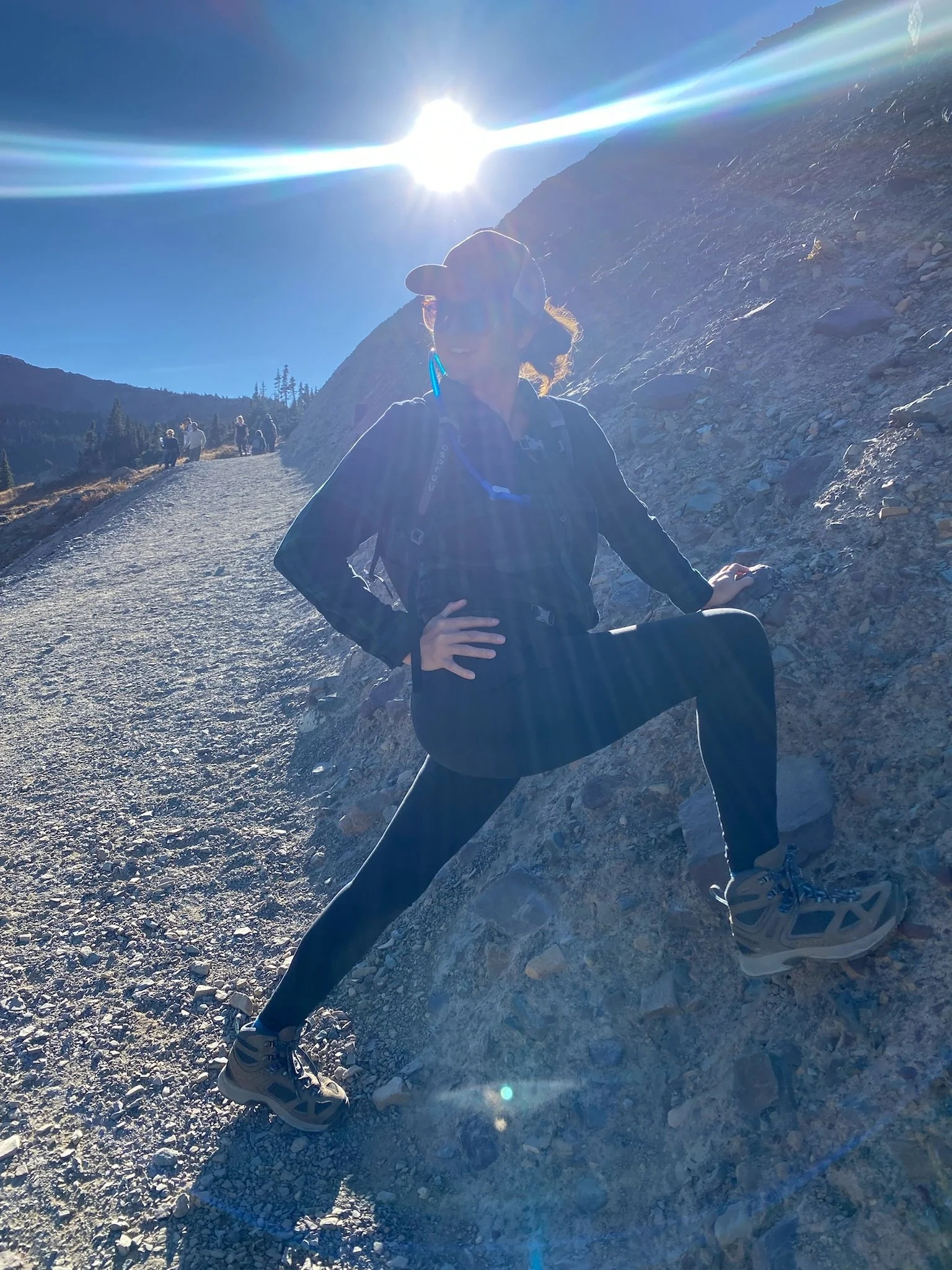 Melanie Connolly Hiking in Montana, with the sun glowing in the background.