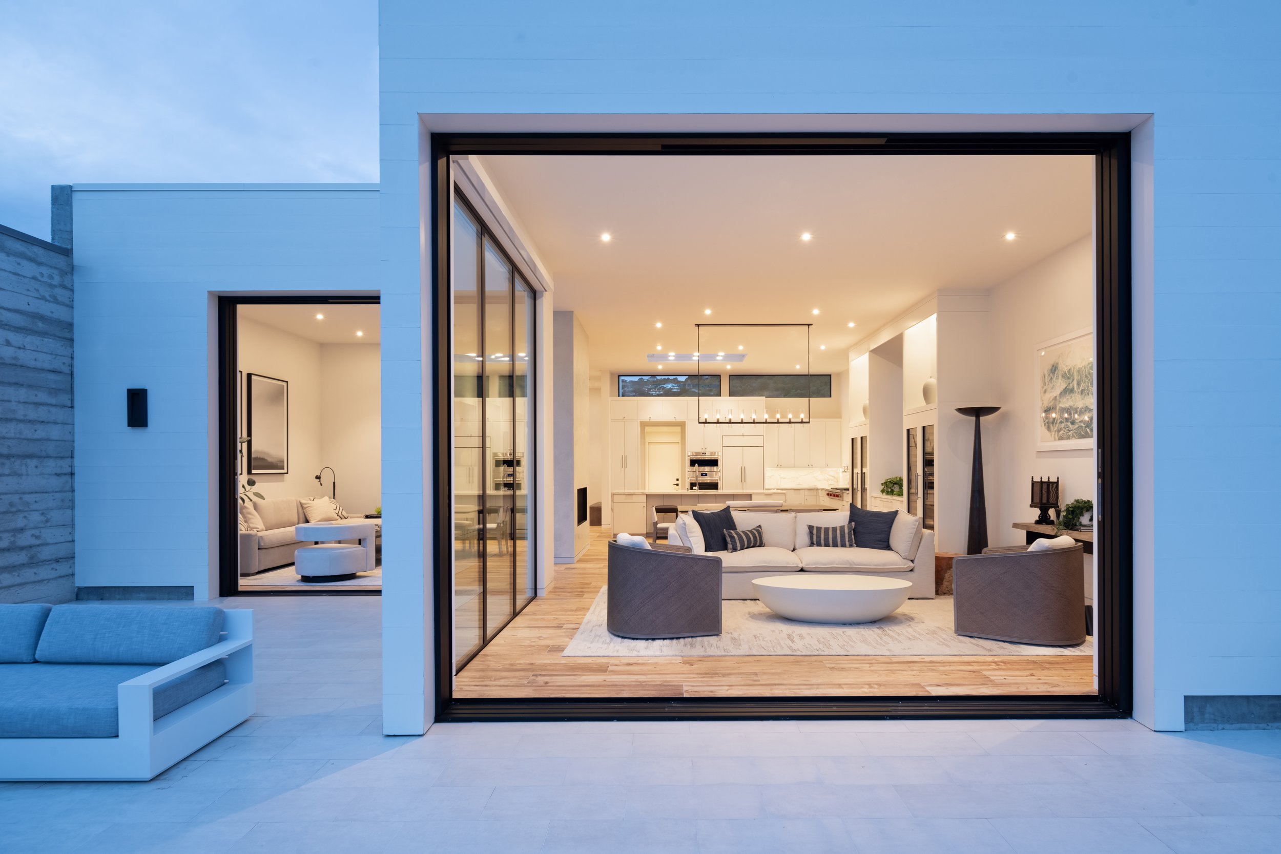  A view to the interior through the large glass partition. The combination of concrete, steel, and painted wood siding creates a material and visual palette that is modern and clean yet also grounded along the edge of the water.  