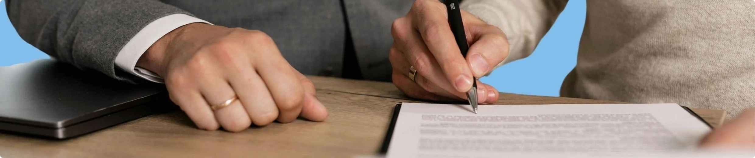 hands signing a document