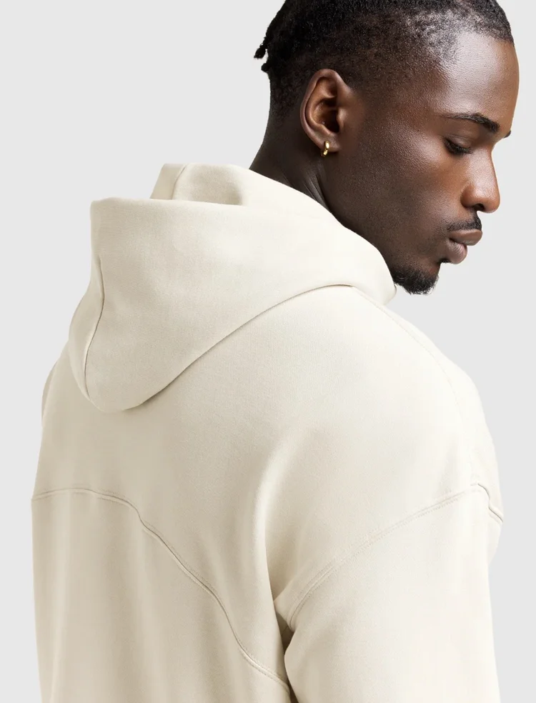Side profile with closely braided hair and a cream athletic hoodie