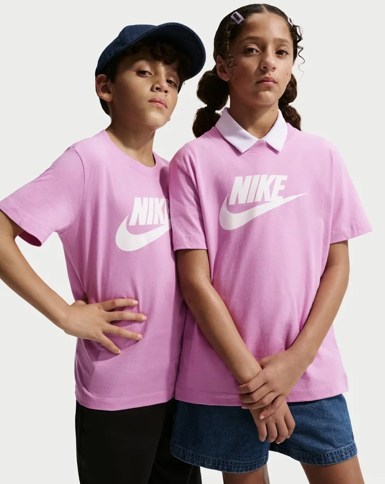Two young models wearing pink Nike T-shirts against a light studio backdrop