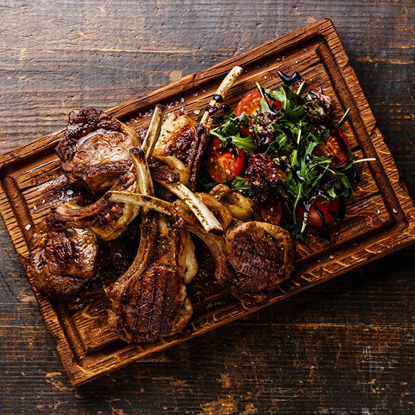 Lamb cutlets on a wooden board.jpg