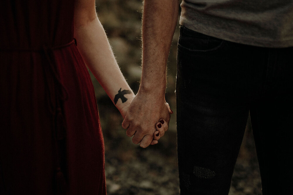  woman and man holding their hands bird tattoo on her wrist 