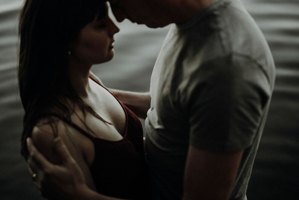  moody portrait of a couple with water in the background 