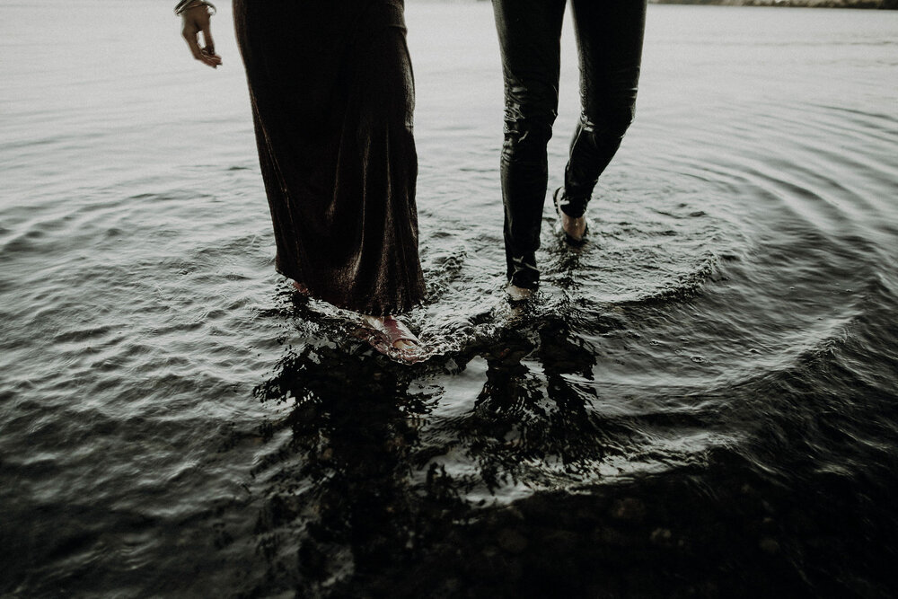  a couple walking out the water in clothes 