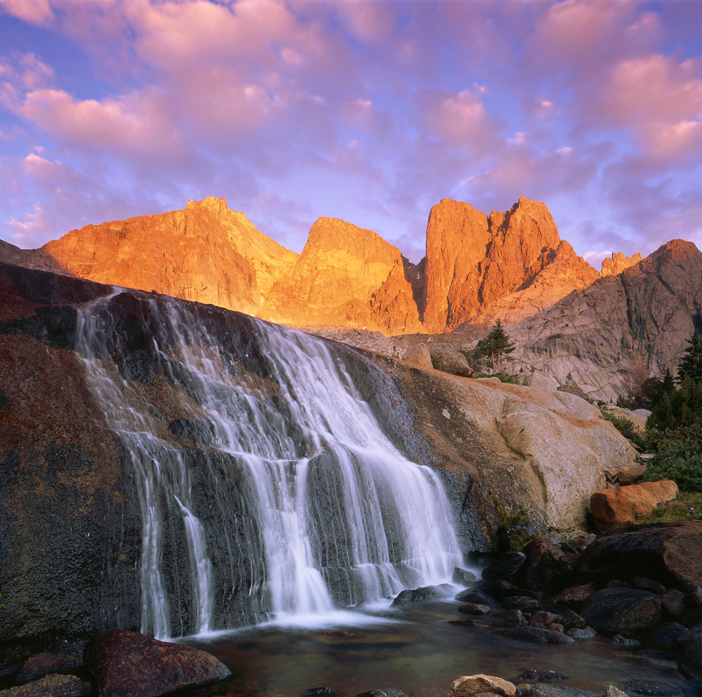 "Granite Flow" - An epic sunrise over the Cirque of the Towers in the Wind River Range of Wyoming. The unusual waterfall flows over a slab on granite in front of the rocky crags and peaks. Prints Available.