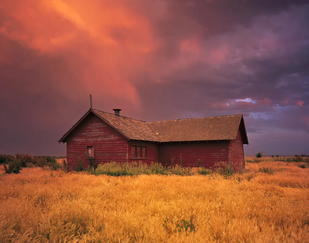 “Barn Storm” - Sunset illuminates a passing thunderstorm, creating a warm glow on this old rural scene. Prints Available.