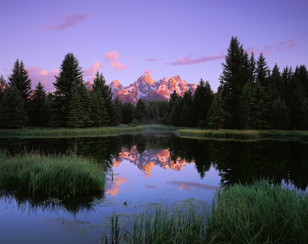 “Teton Reflections” - Velvia 50 4x5, 90mm lens - 8 seconds at f32, 2 stop soft GND filter. In order to be ready in time I had to set up and focus well before sunrise. I was easily able to focus on the peaks where they met the sky in the dark, as well as the foreground grass where it meets the water. Those objects have strong enough contrast so that focus can be nailed even in dim light.