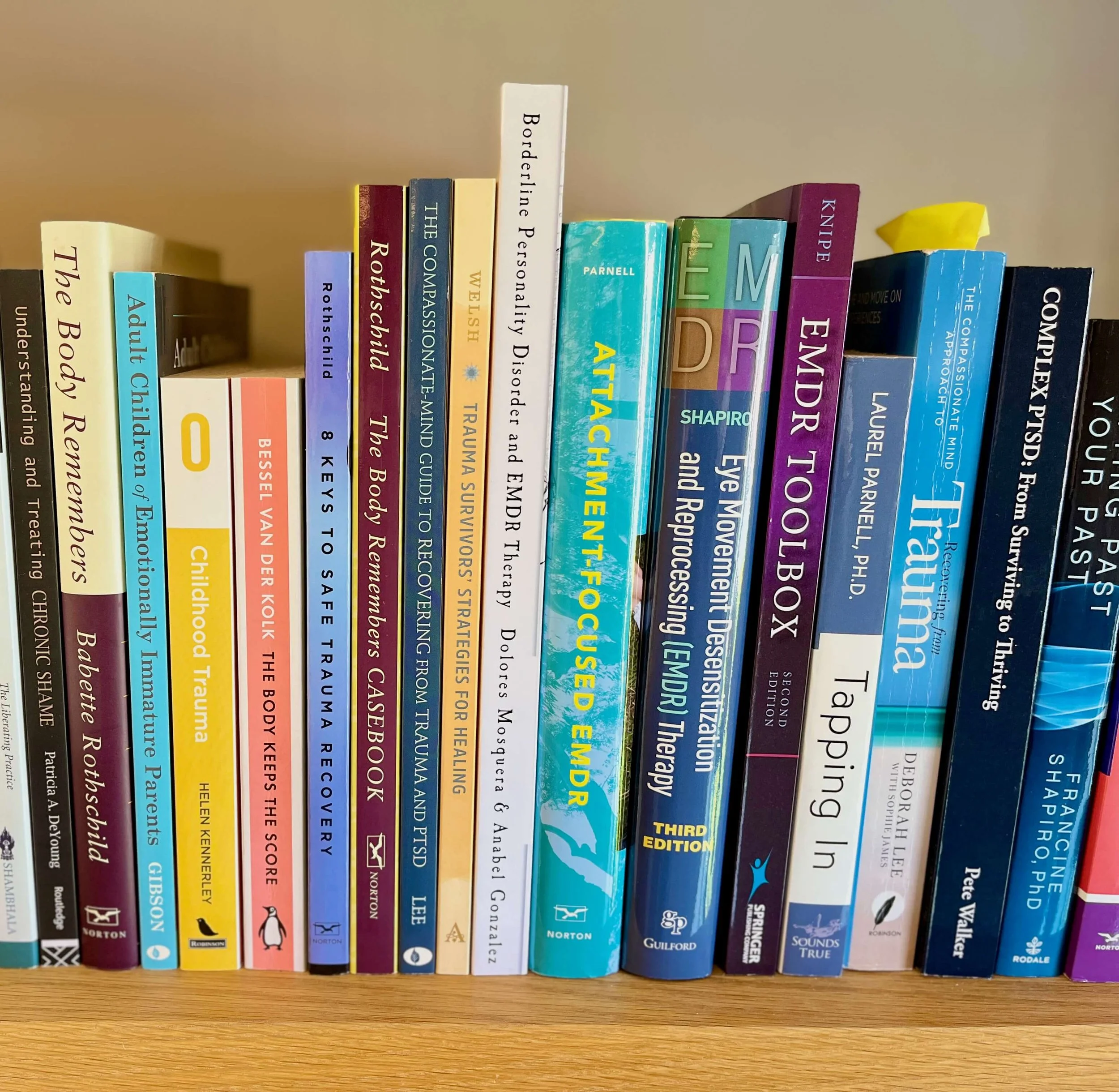 A close up of trauma therapy books on a bookshelf — supporting EMDR and counselling for anxiety, emotional overwhelm and difficult past experiences