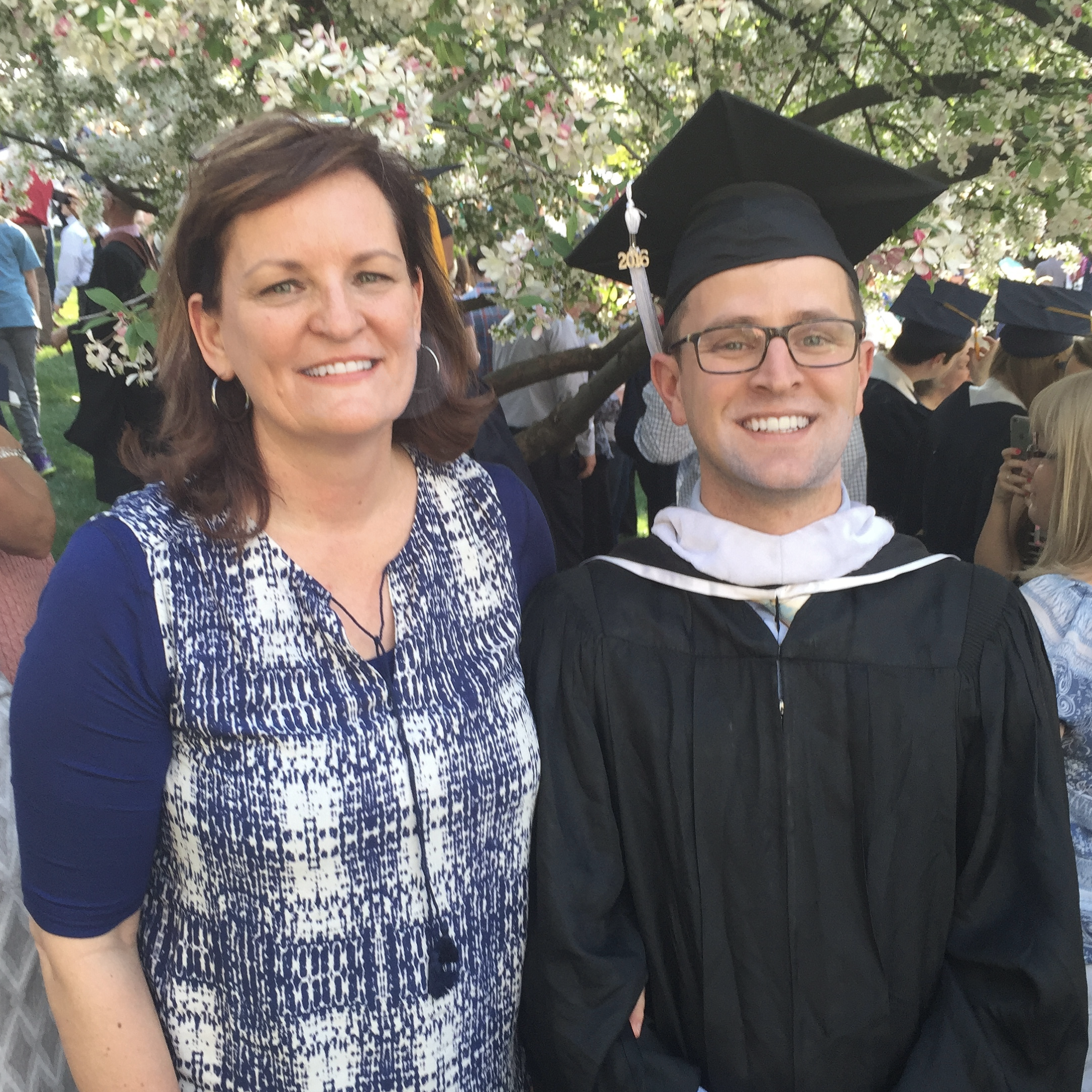 Ellen King standing next to Daniel King in his graduation cap and gown.