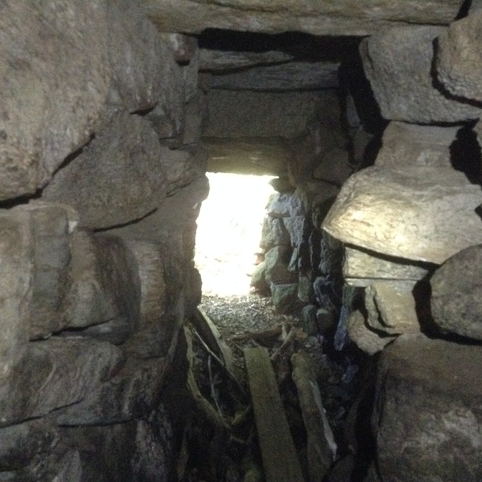 Above: looking out from the point of transition between the passage and the corbelled chamber (which is behind the viewer). Note the size of the horizontal "roof slabs," all of which are "underground." When the visitor approaches the chamber for the first time, the approaching trail leads them to a point at which they are standing on the earth that is above this underground passage and the domed chamber behind.