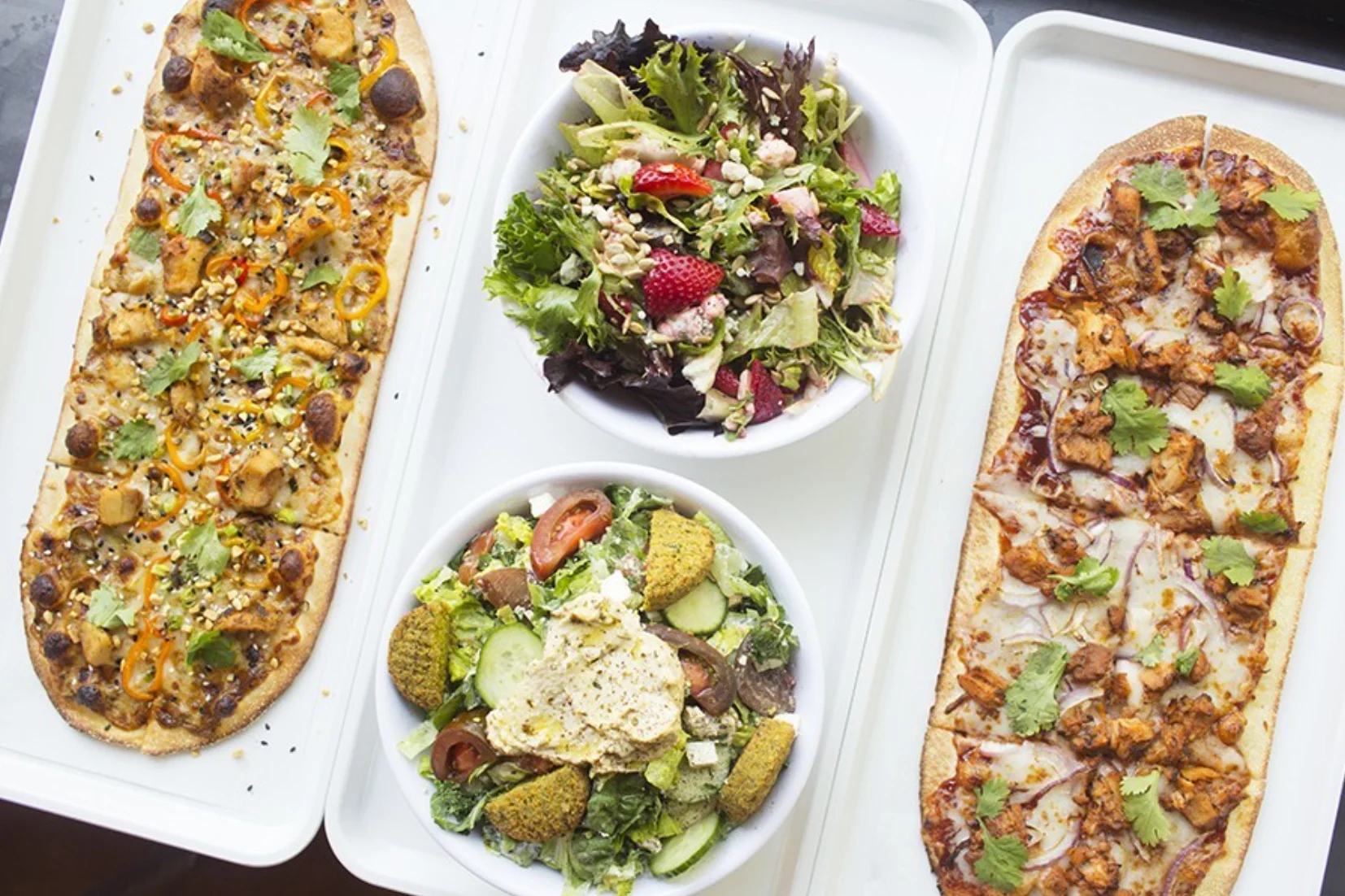 PHOTO BY MABEL SUEN Pies at 'Zza include the "Thai Dye" (left) and "Postrio" (right), as well salads and even a poke bowl.