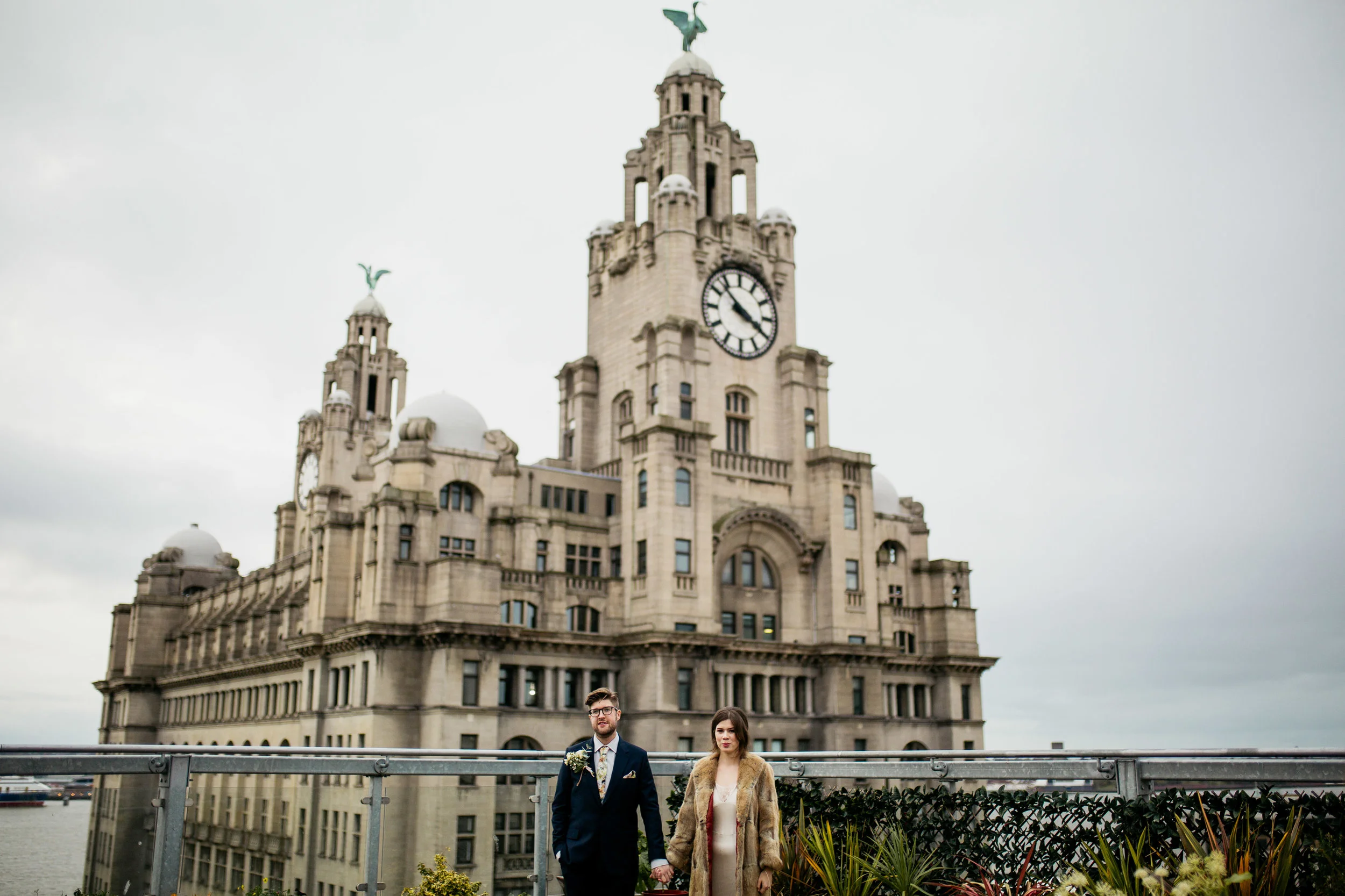 Bride and groom in front of the Liver Building, Liverpool at Oh Me Oh My wedding in winter