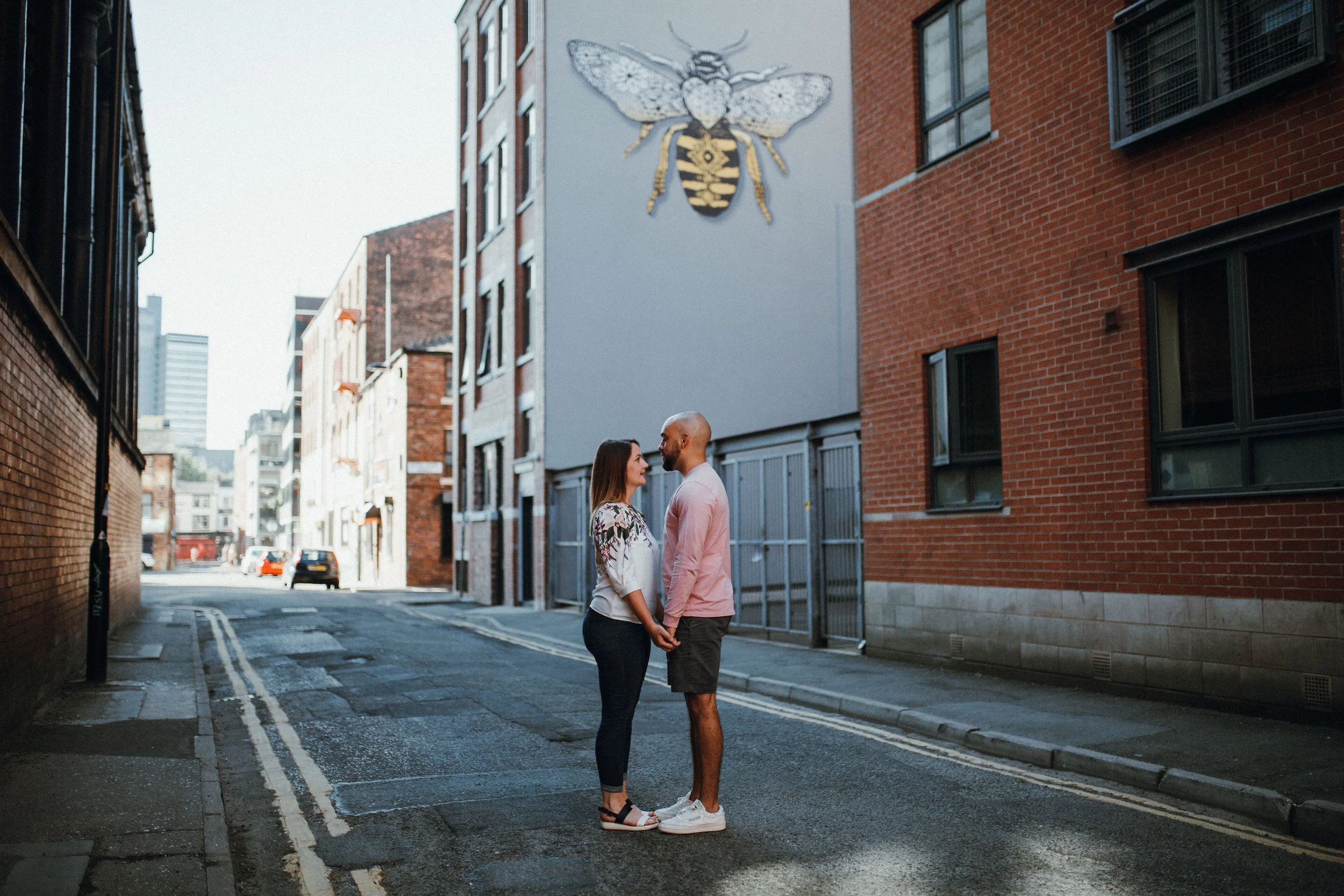 Couple holding hands under Manchester bee