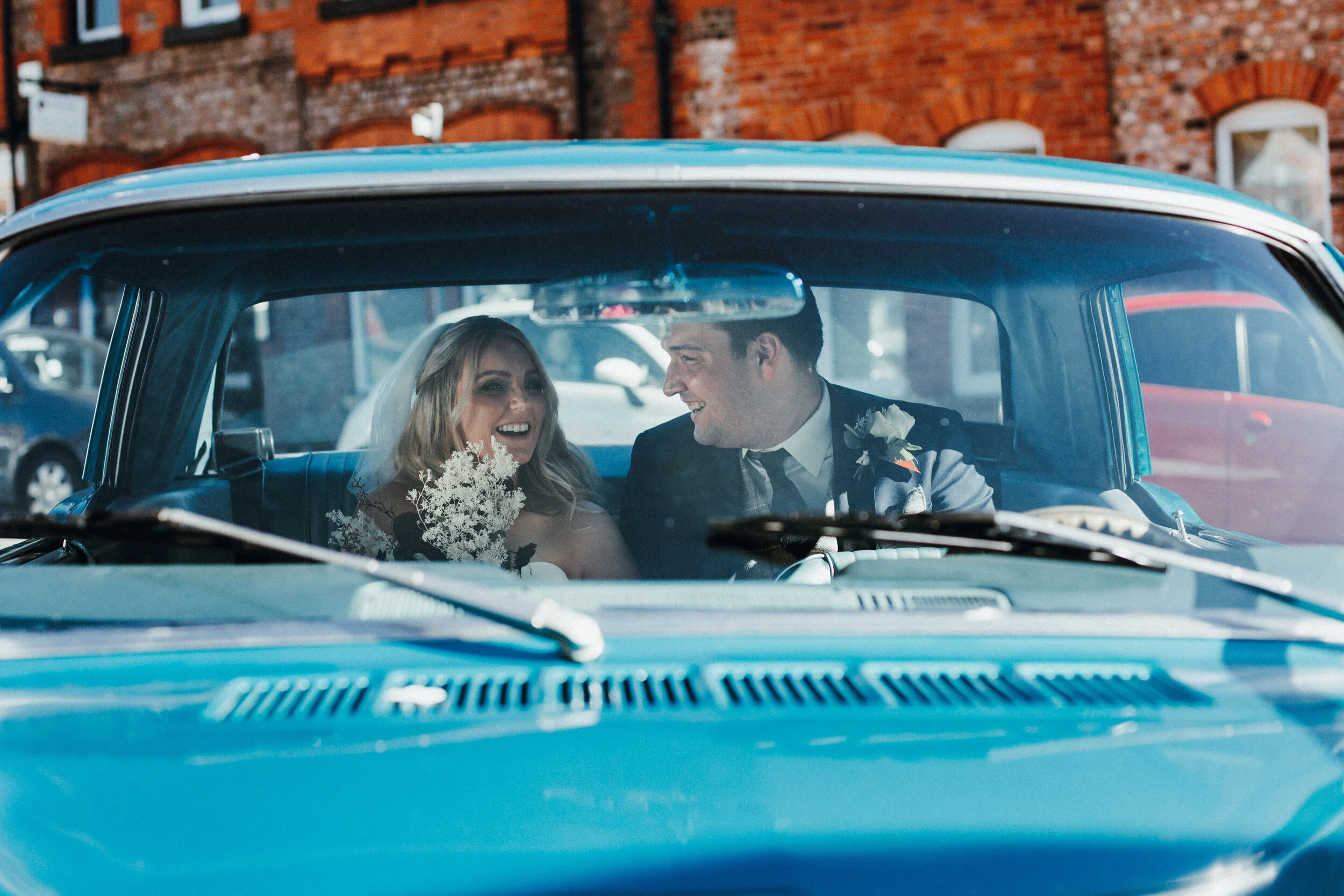 Bride and groom in 1966 blue Mustang