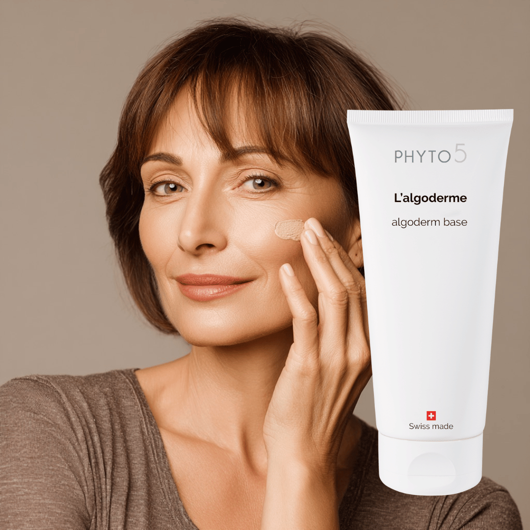 A woman applies a small dollop of Algoderm Base Mask to her cheek