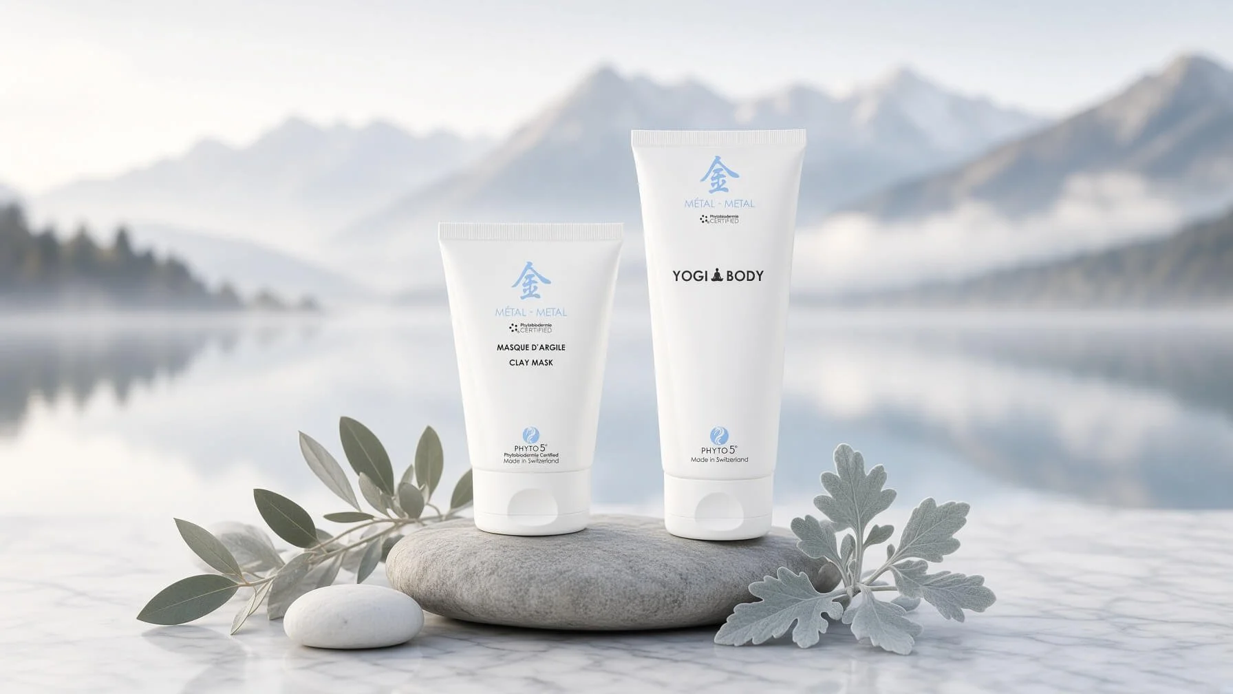 PHYTO5 Metal Perfect Pairing for Fall: white Clay Mask and Metal Yogi Body Gel on stone beside a misty alpine lake