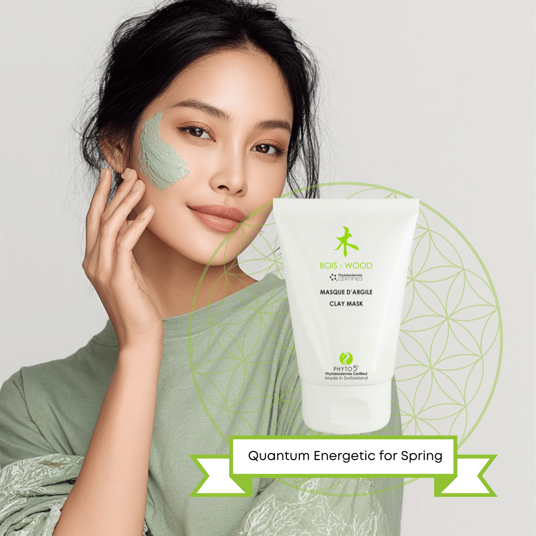 A young Asian woman with a smear of green Clay Mask on her cheek