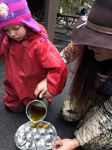 Pouring medicinal salve into containers