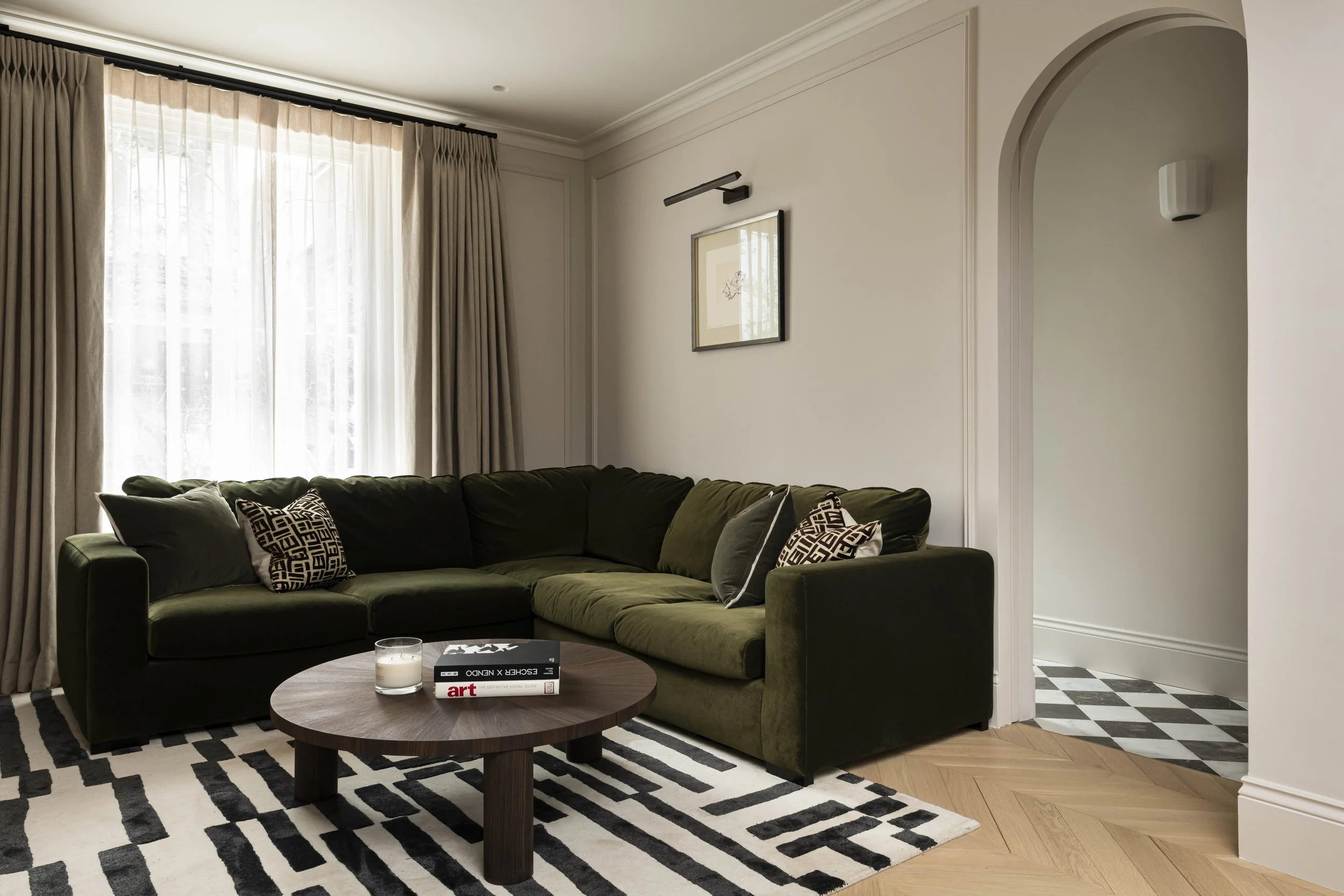 Olive green sofa with arched pocket door living room in a Victorian house refurbishment by Studio Zeal