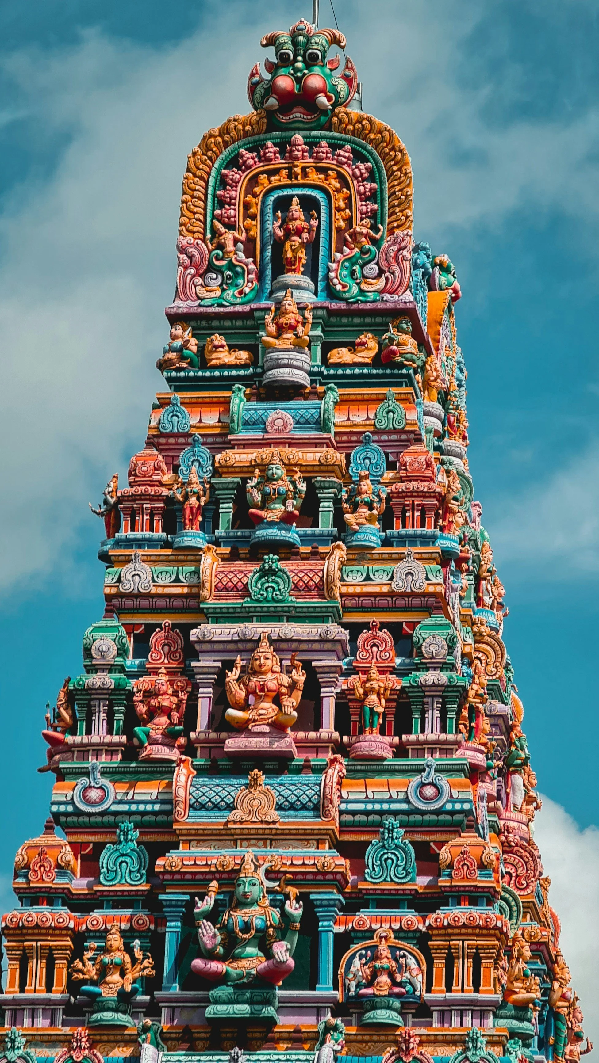 A colorful, tall Hindu temple covered with figurines in the south of India