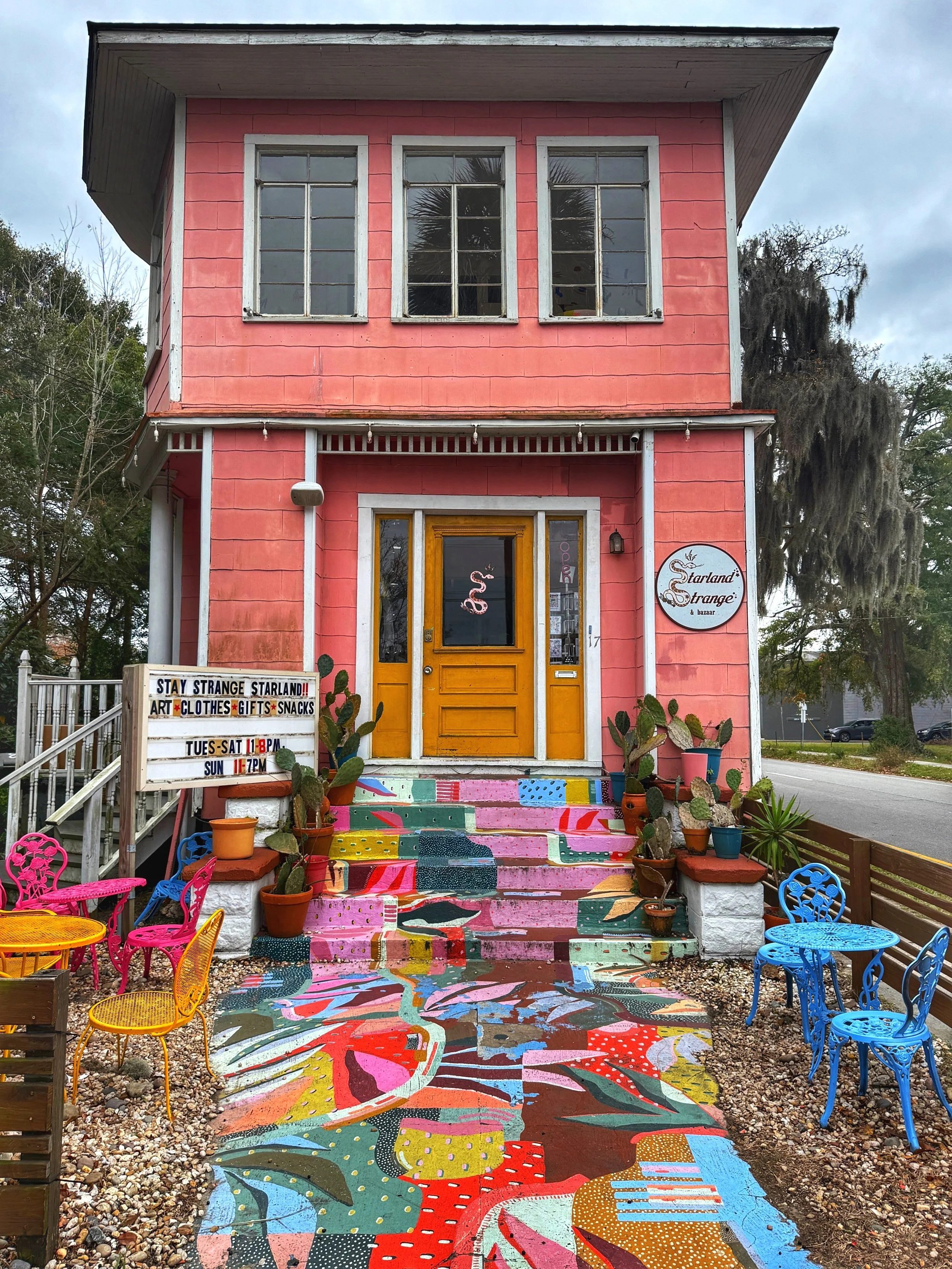 Facade of Starland Strange & Bazaar, with it's pink exterior and vibrant painting path and stairs