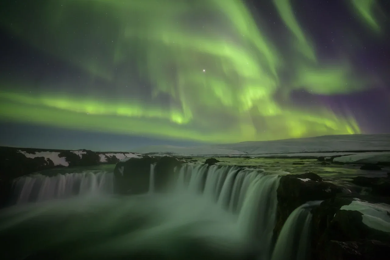 The Northern Lights above the waterfalls at Godafoss, Iceland