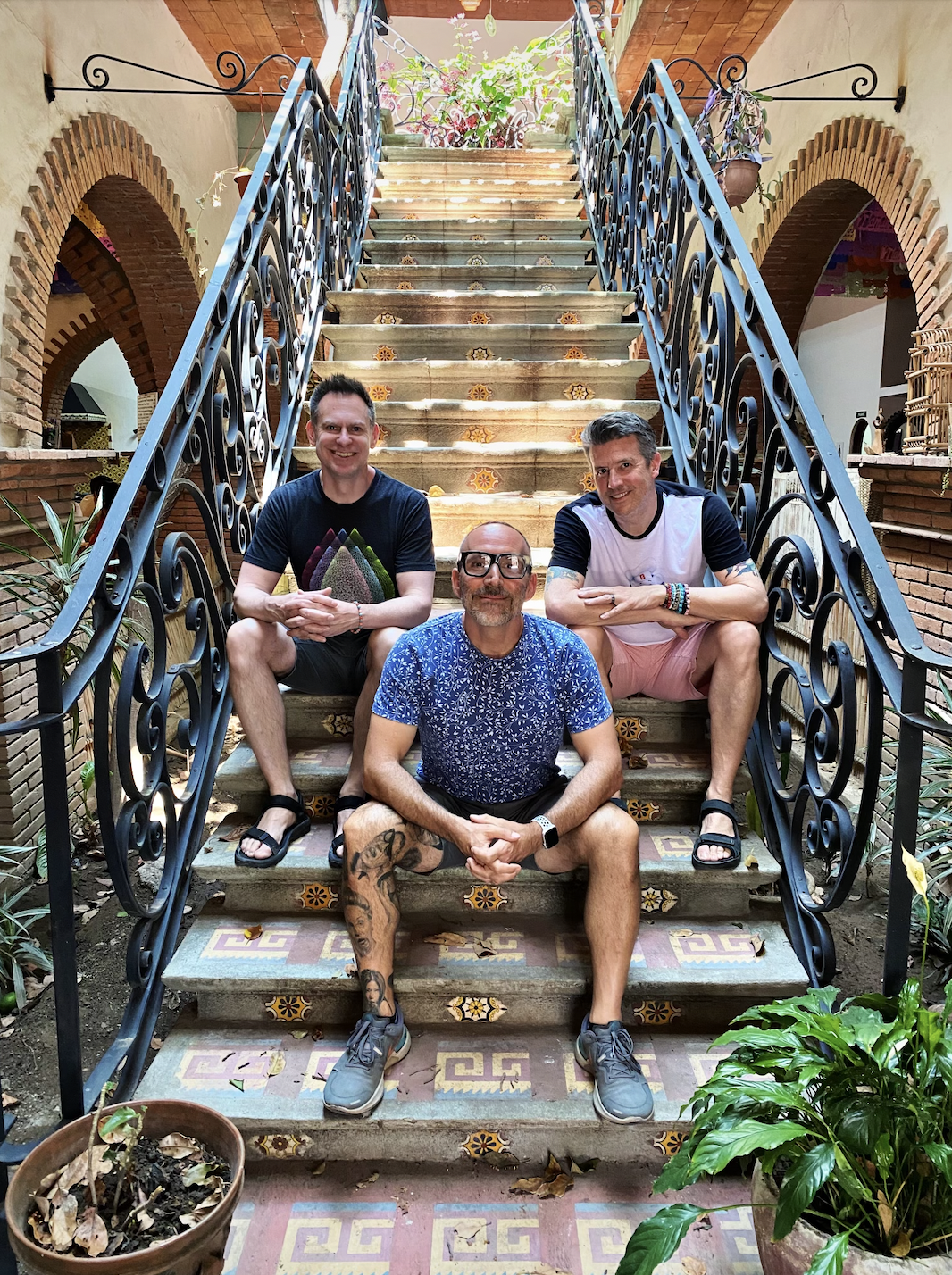 Three men sitting on staircase at Tlamanalli restaurant in Teotitlán del Valle, Mexico