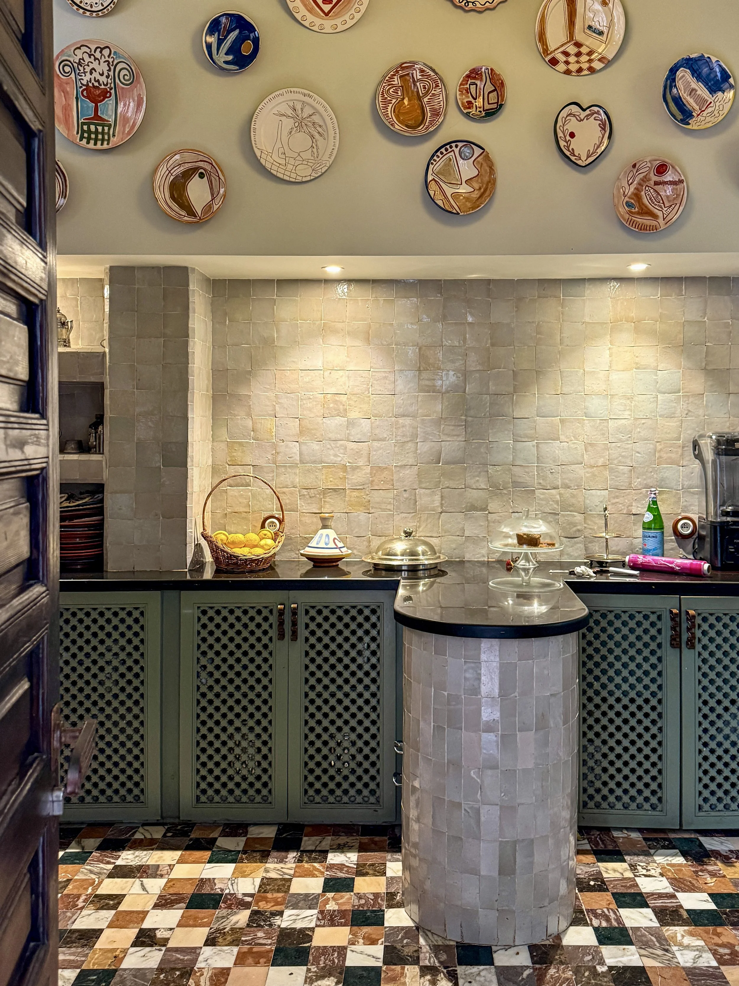 The kitchen at Riad Rosemary in Marrakech, with hand-painted plates by Leenaert and mashrabiya-style cabinet doors