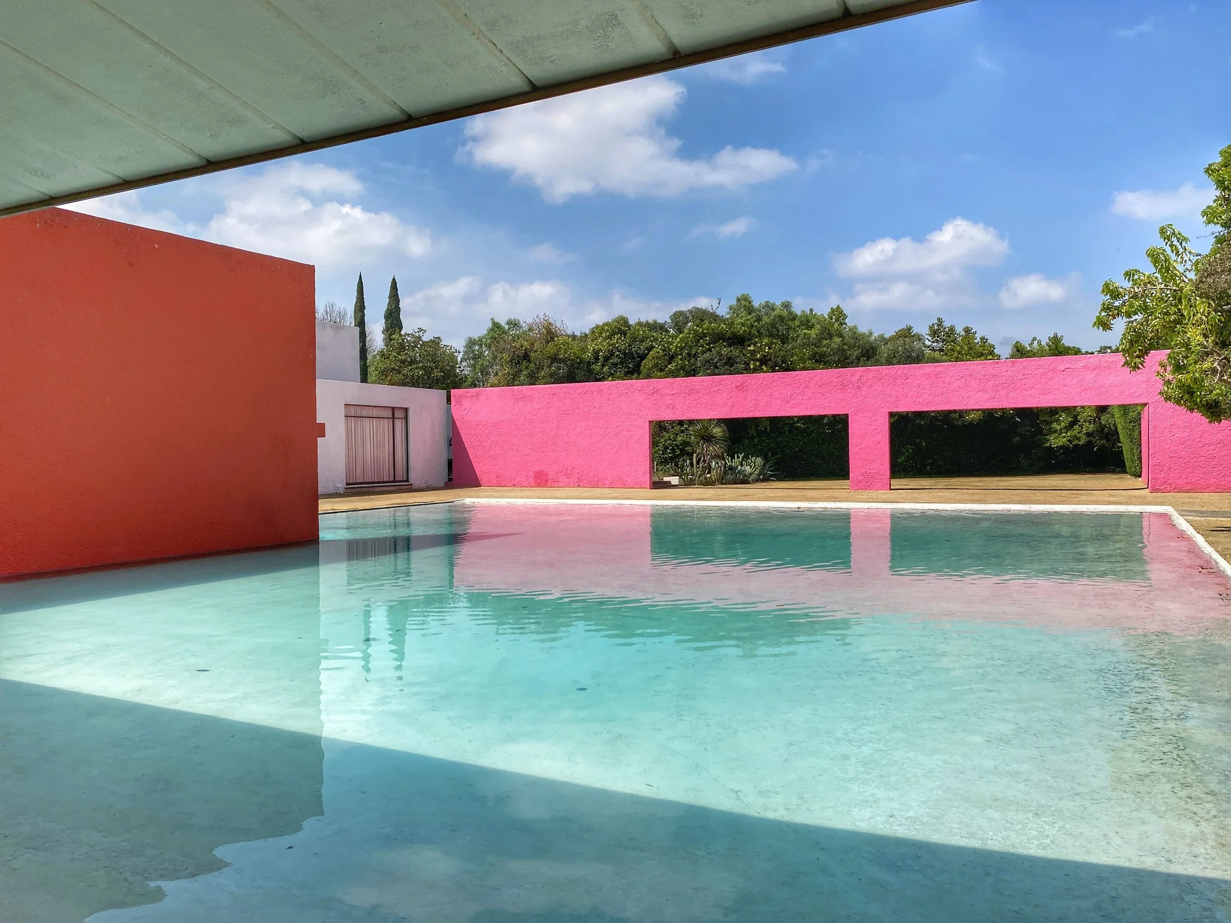 A pool by brightly colored minimal modern walls at Cuadra San Cristóbal byarchitect Luis Barragán outside of CDMX