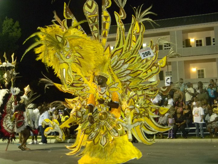 How do the dancers support such enormous costumes during the Junkanoo parade in the Bahamas?