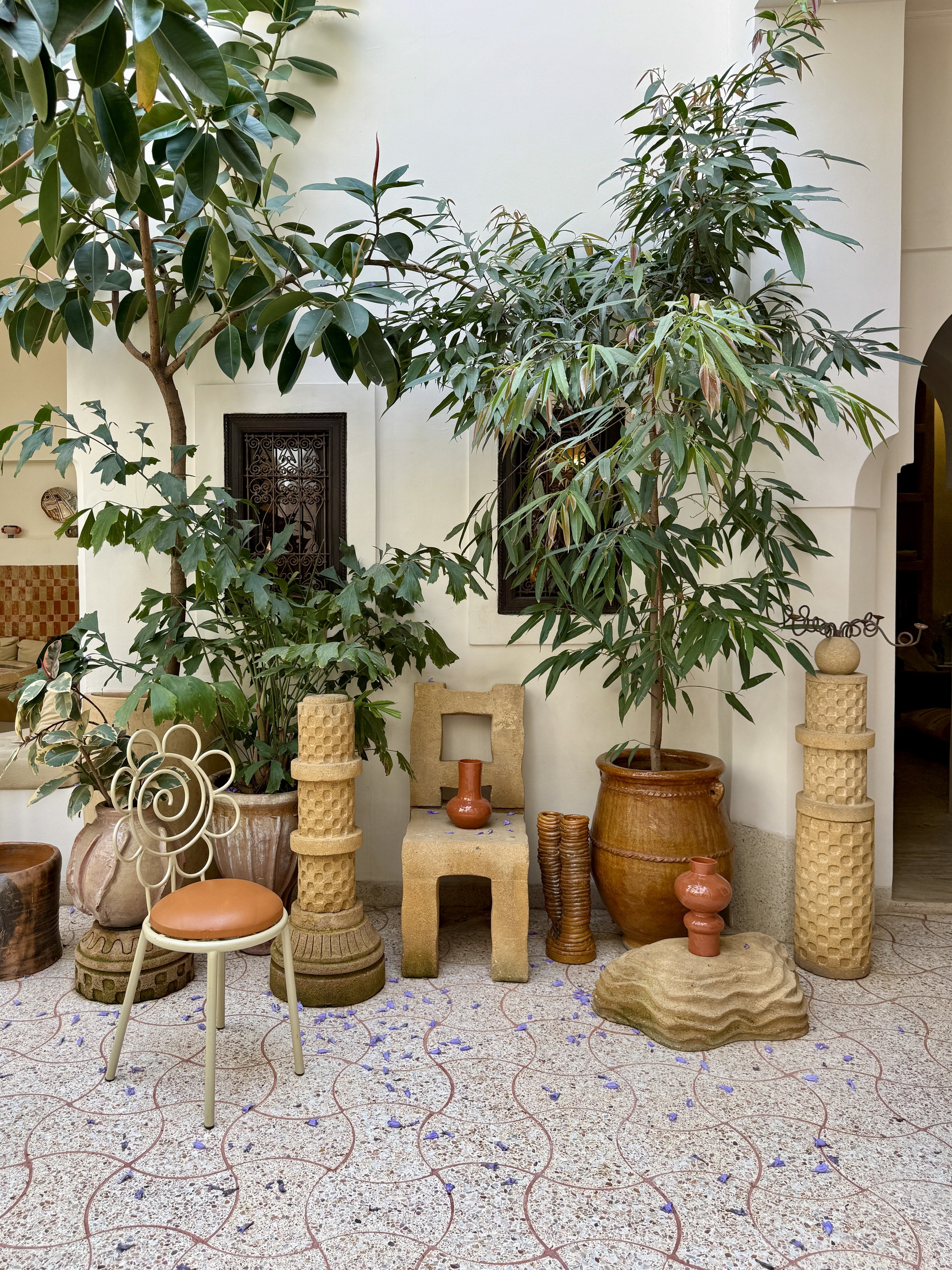 Whimsical chairs and pots with plants in the interior courtyard of Riad Rosemary in Marrakech