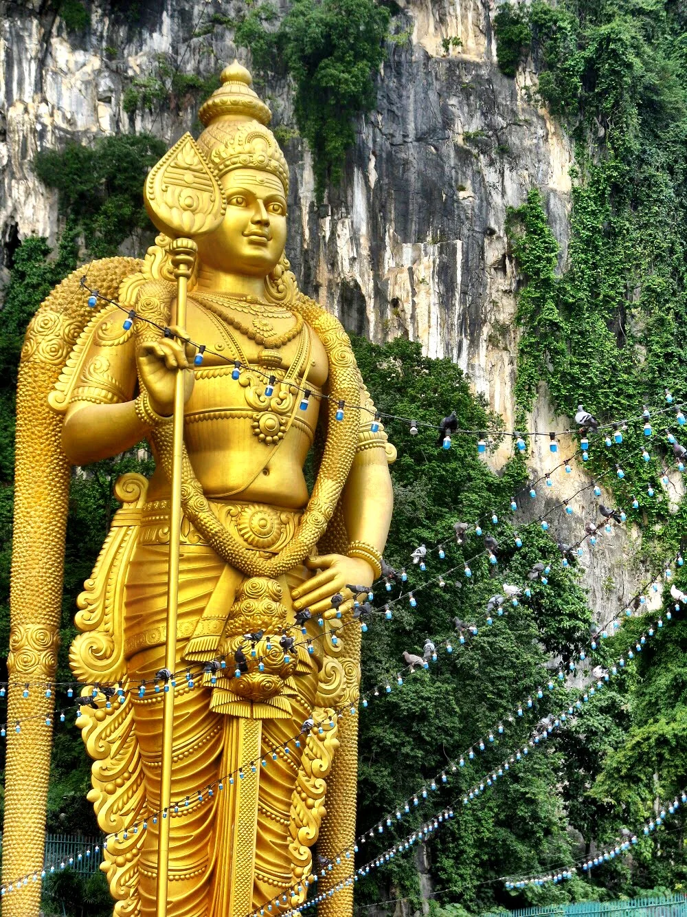 The gold statue of Lord Murugan rises 140 feet into the air