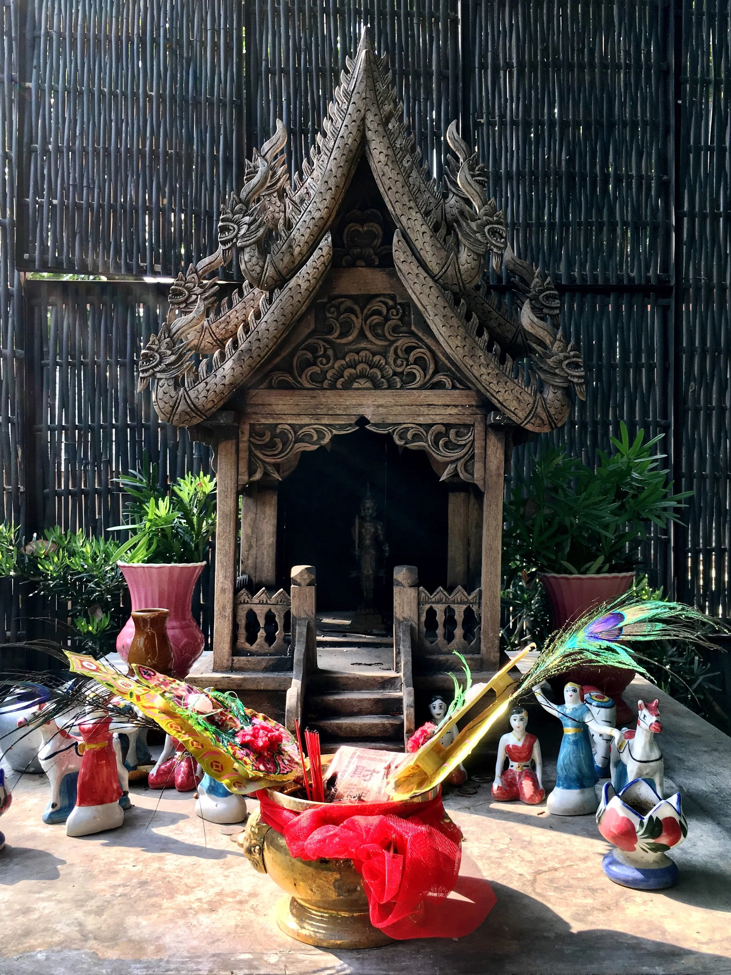 Wally and Duke gave offerings of fruit and said prayers at the spirit house on the grounds of their hotel