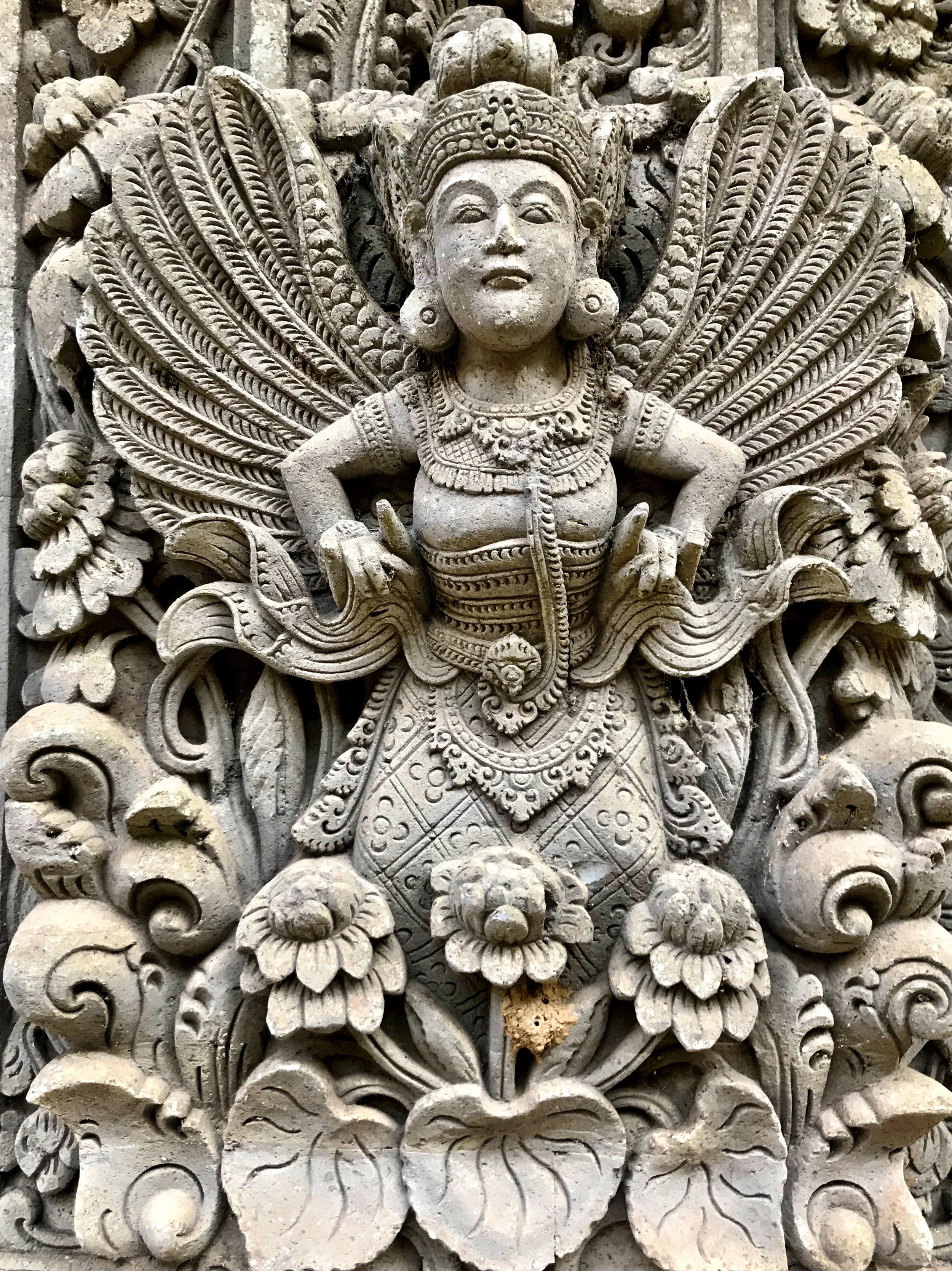 A shrine surrounded by bidadari, celestial female spirits, emerging from clusters of lotus flowers