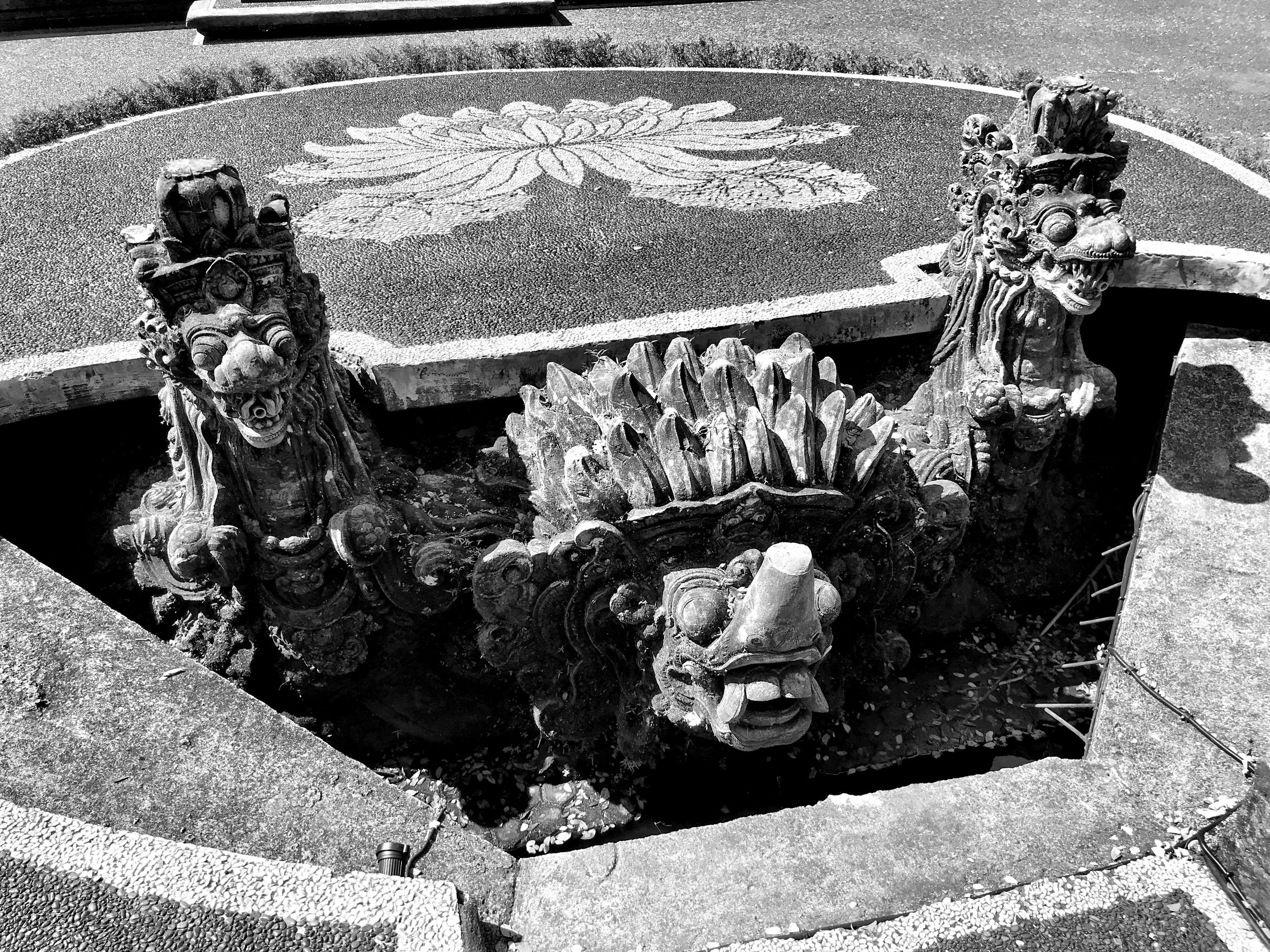 On a platform in front of the temple, a spiny-backed turtle flanked by two dragon-looking creatures emerge from below