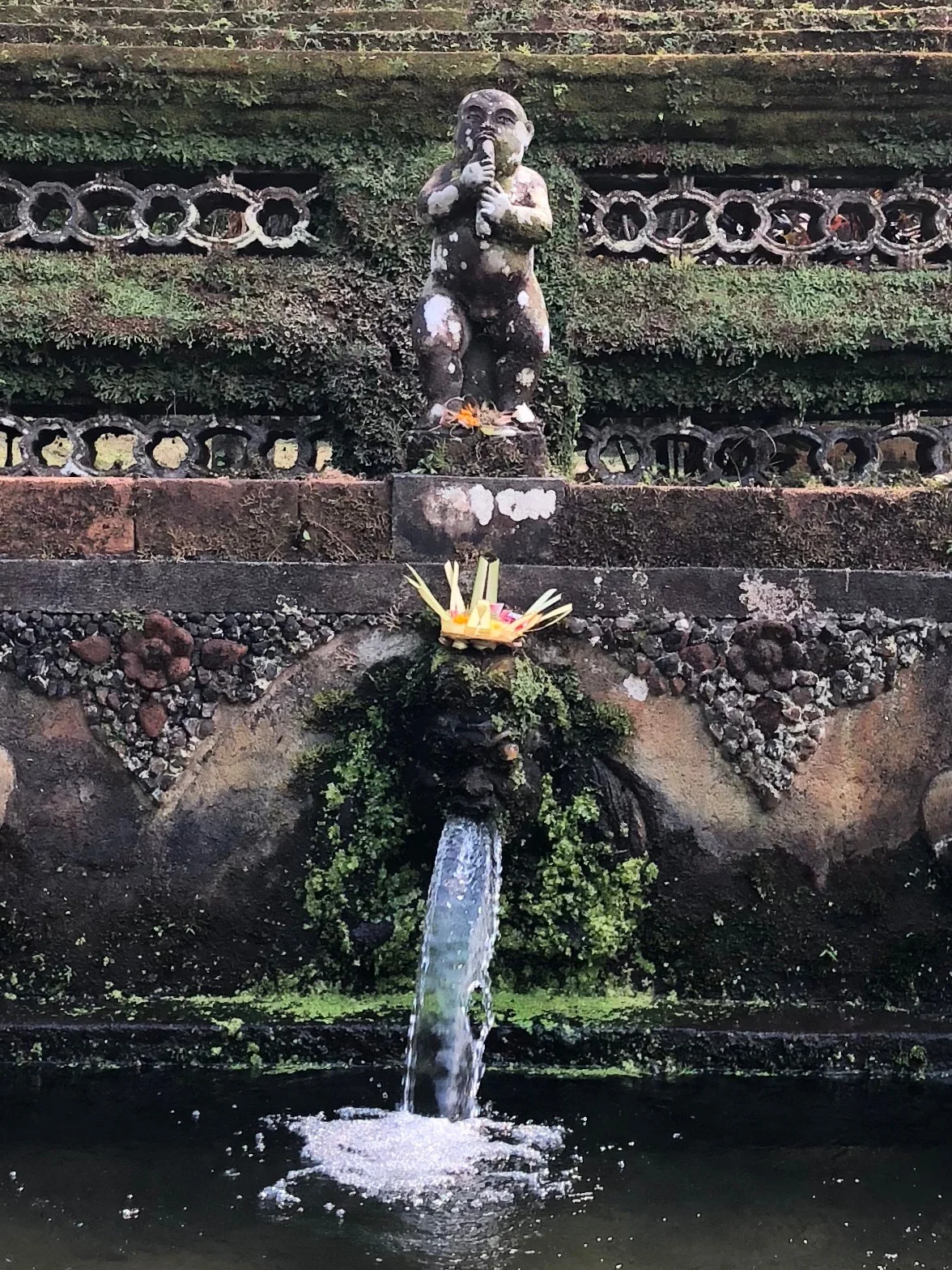 Water pours from the weatherworn carved faces in the bathing pools