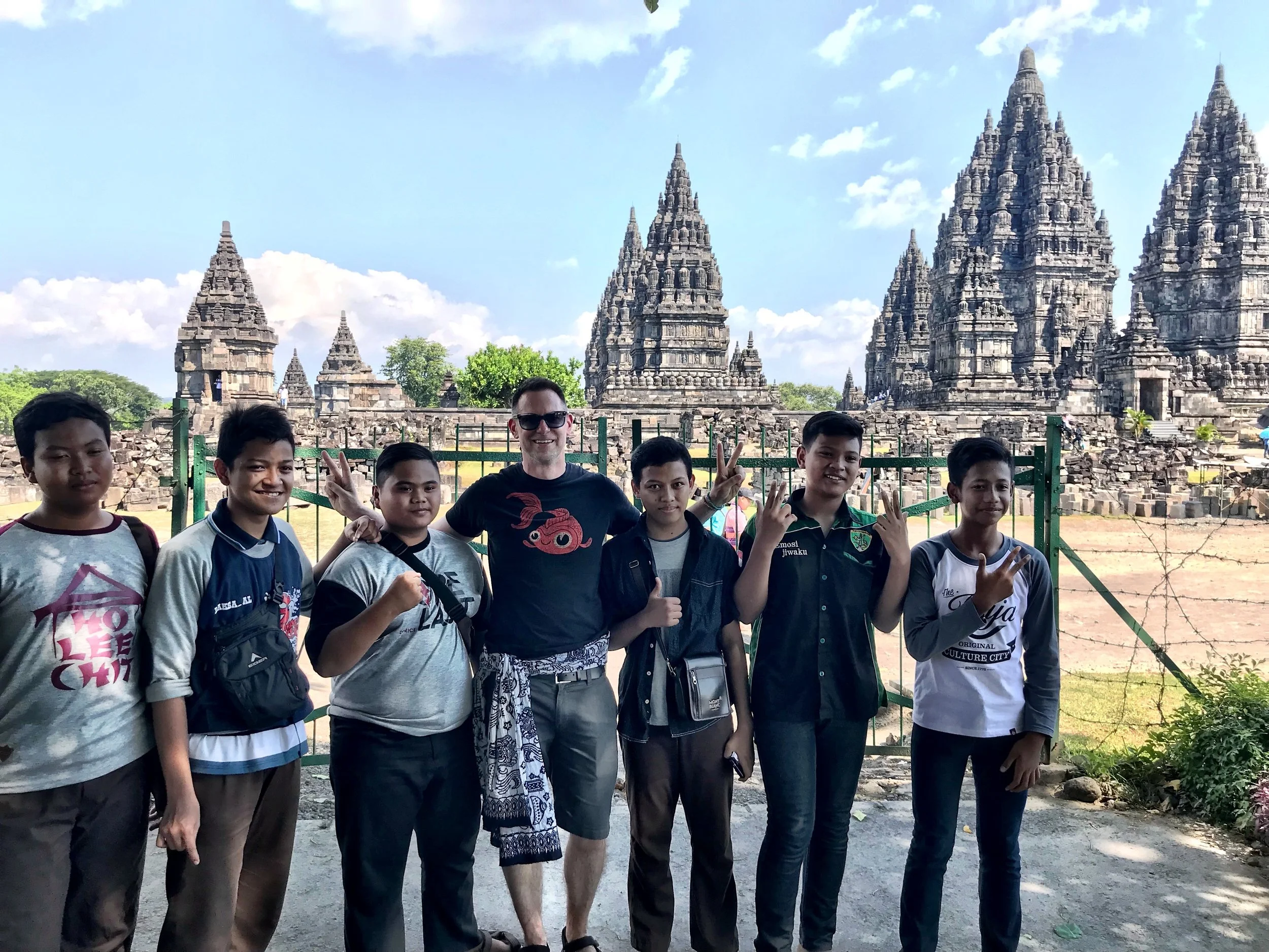 Duke poses with a group of local boys, with Prambanan behind them, looking like a fake backdrop