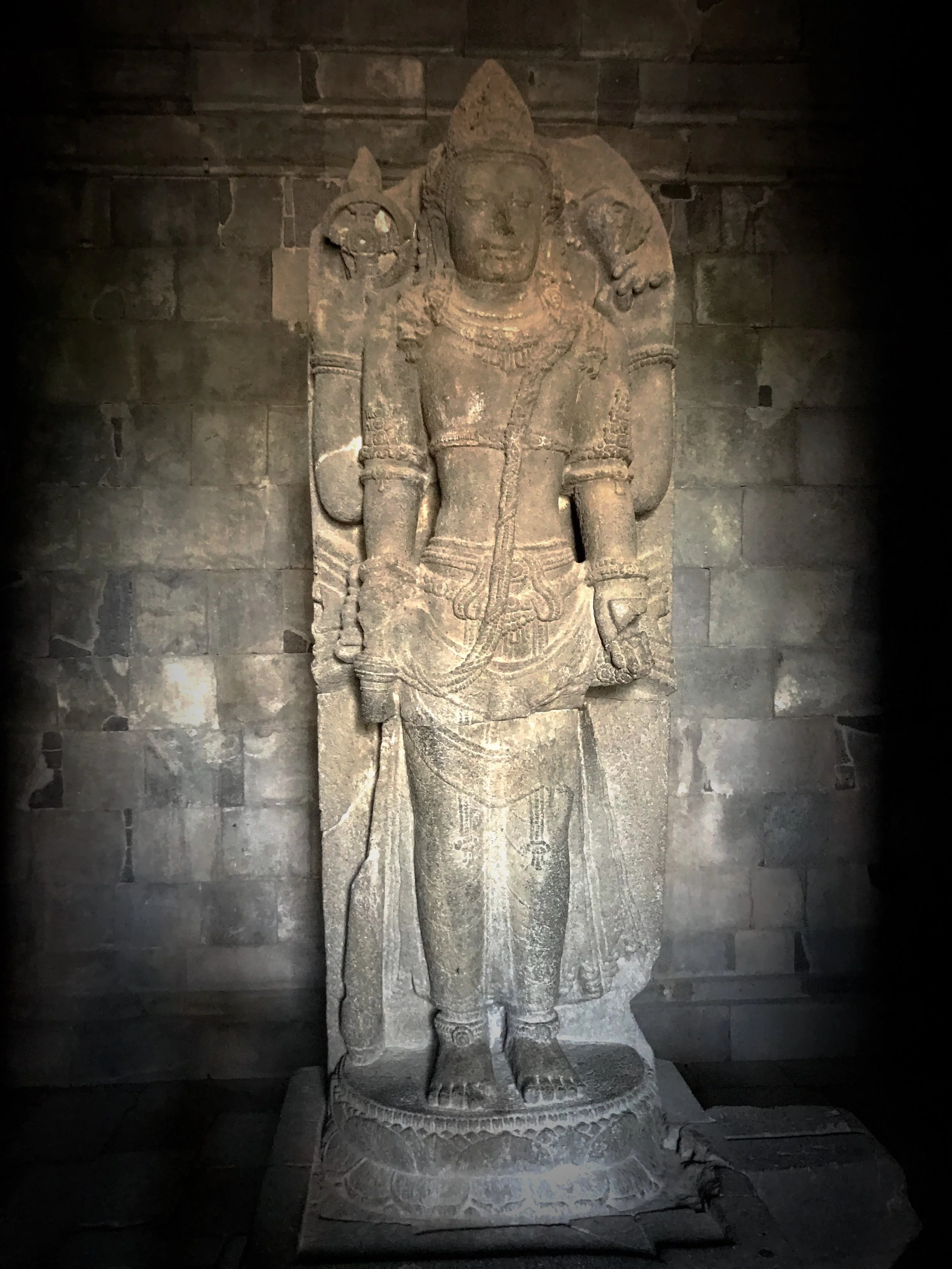 Vishnu the Protector holds a discus and conch shell