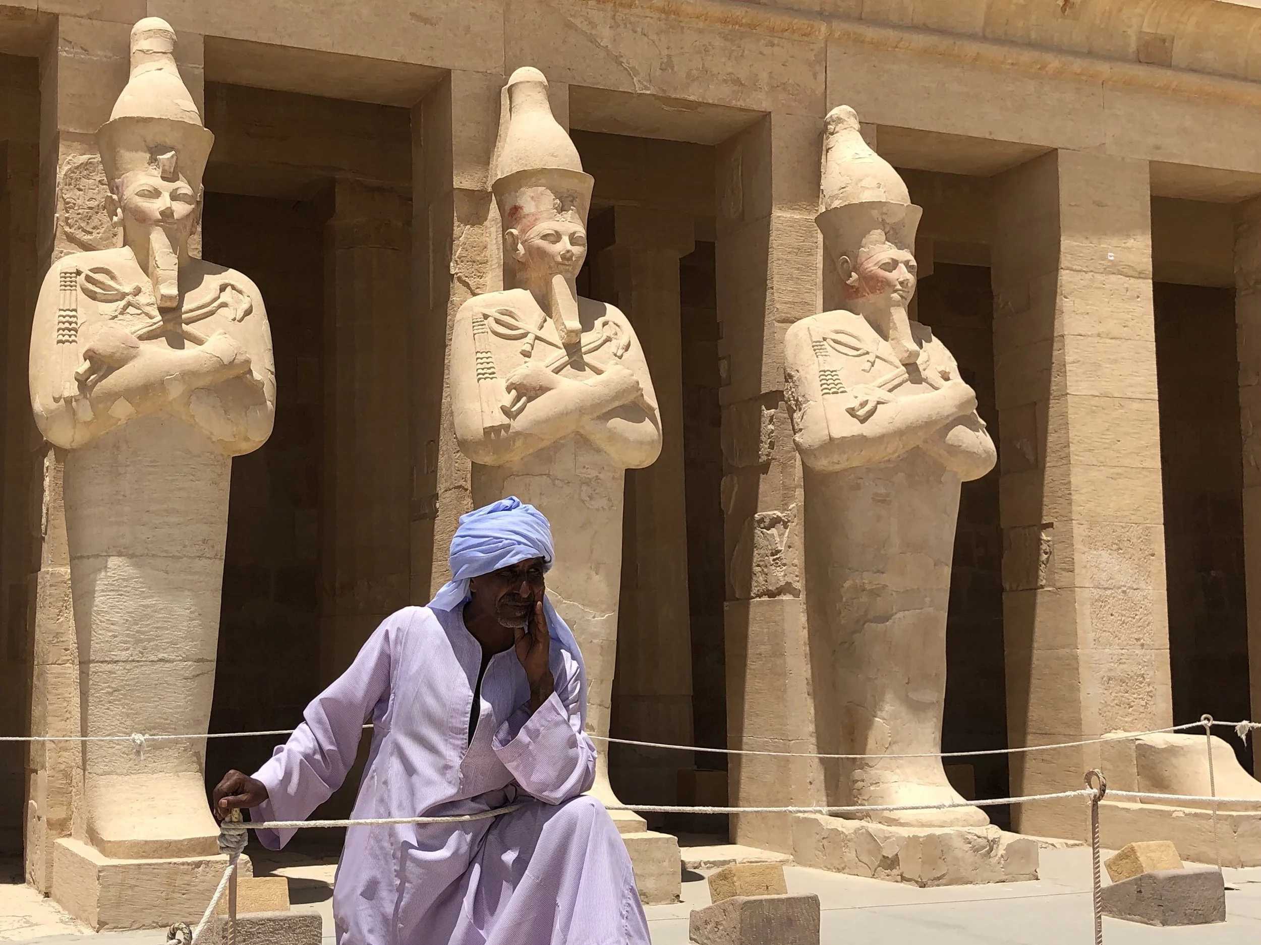 A temple employee in front of some of the statues — note the reddish color on their faces