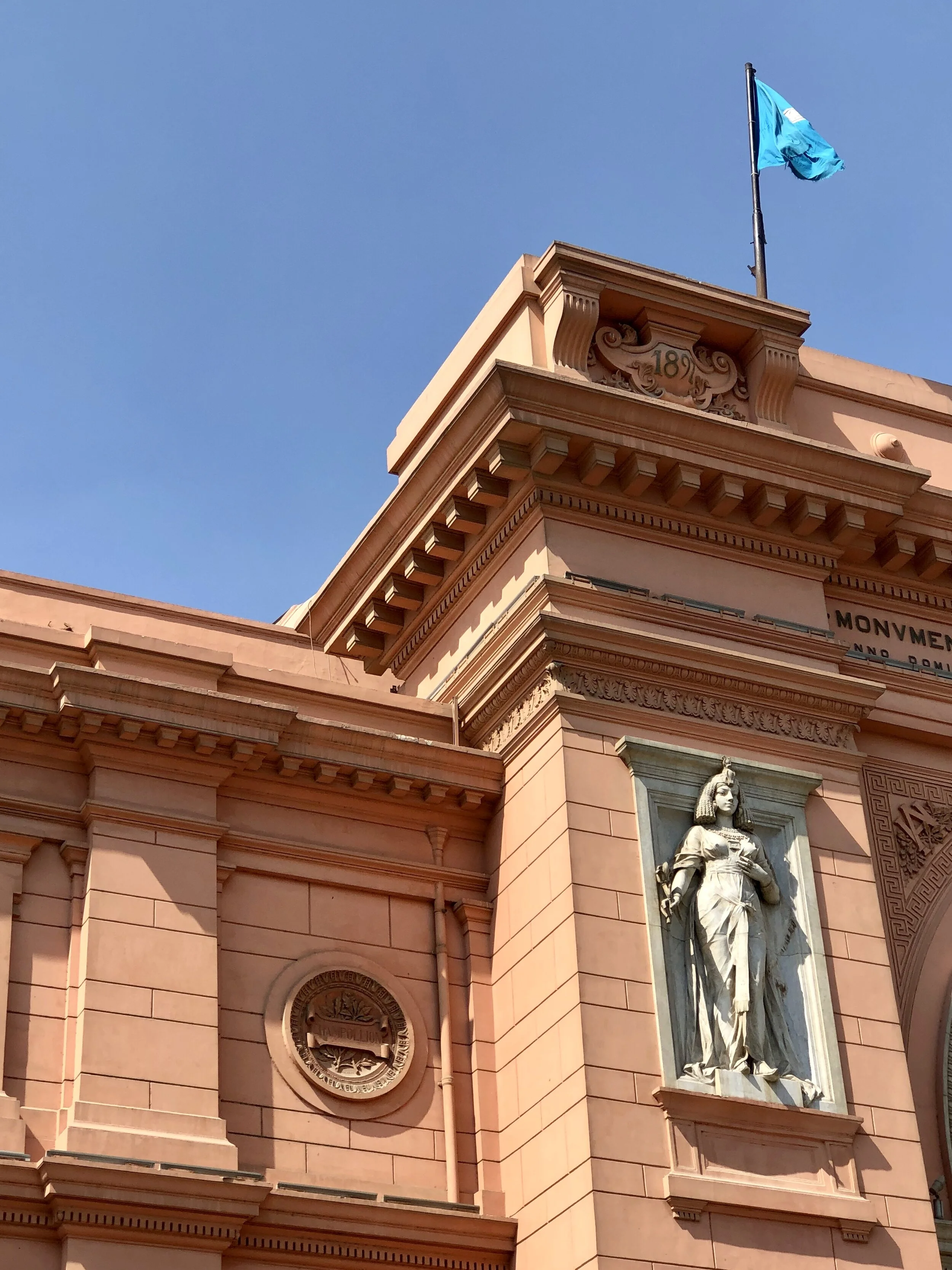 A pair of larger-than-life figures personifying the goddesses of Upper and Lower Egypt adorn the museum’s façade on either side of the entry arch