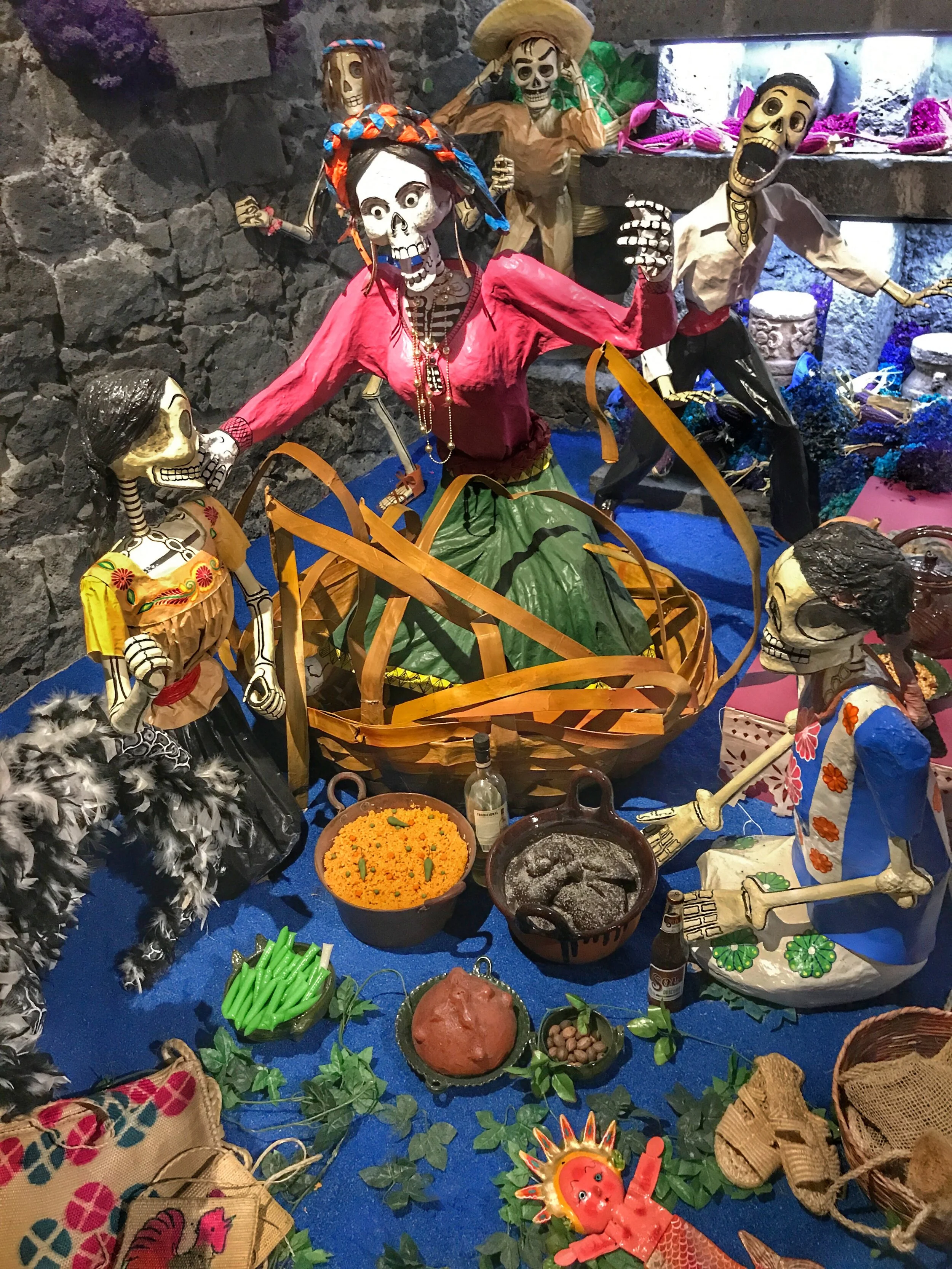 Ofrendas often have skeleton figures and food and other items the deceased enjoyed in life.