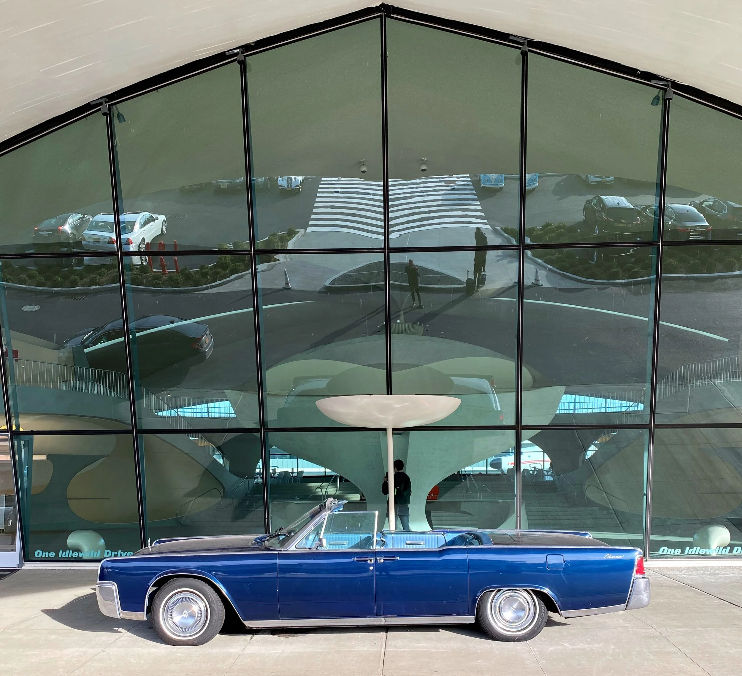 A vintage convertible sits out front of the Flight Center.